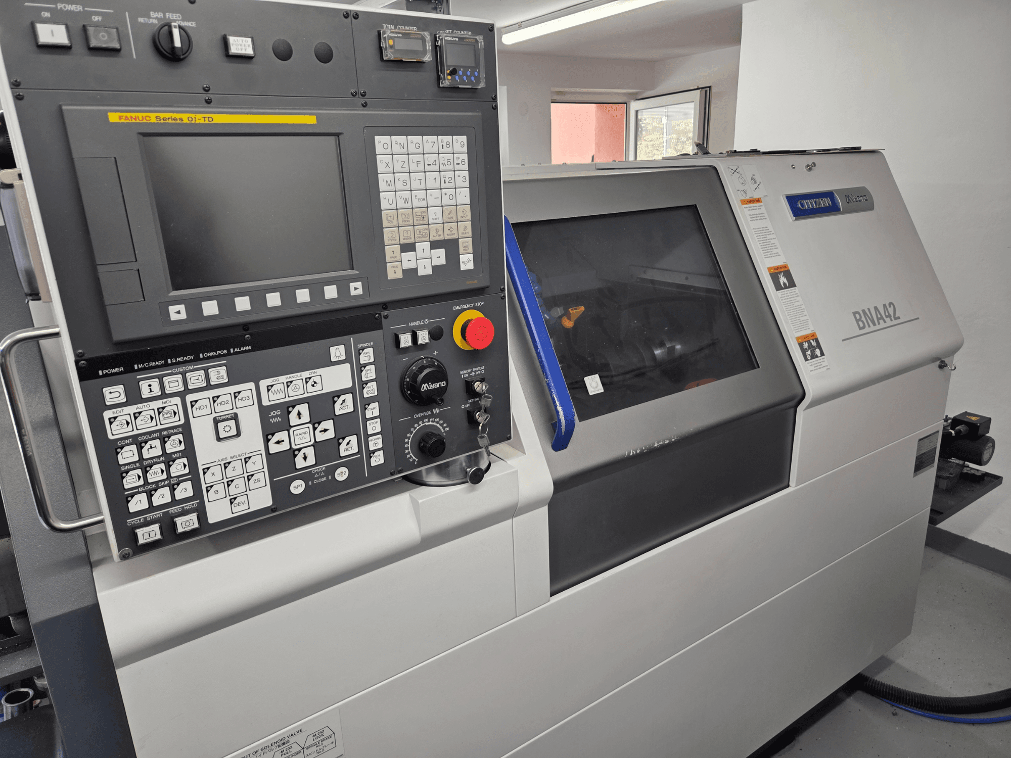 Miyano BNA42S2 horizontālā virpošanas mašīna, skats no priekšpuses, kurā redzams vadības panelis ar FANUC Oi-TD sērijas interfeisu un displeju.