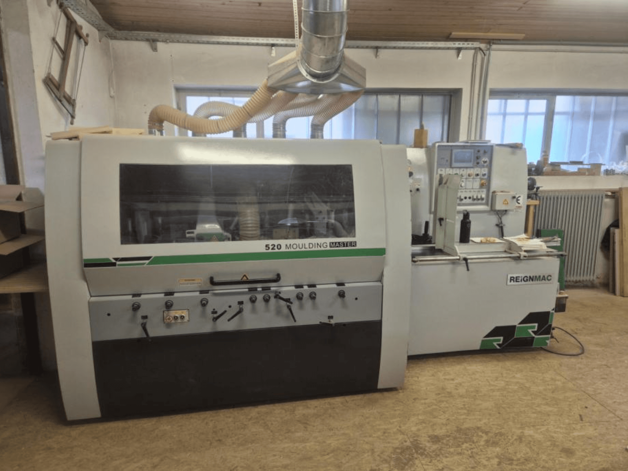 REIGNMAC 520 MOULDING MASTER koka ēveles priekšējais skats, kurā redzams vadības panelis, padeves veltņi un putekļu nosūces sistēma.