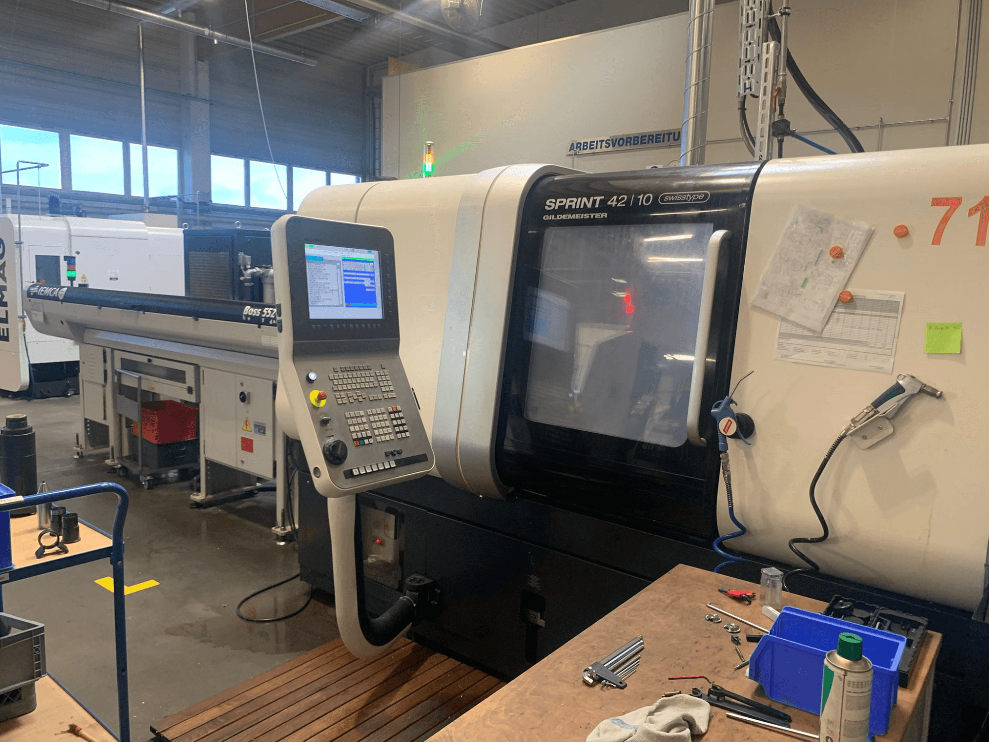 DMG MORI Sprint 42/10 lineārā Šveices tipa virpošanas darbgalds, skats no priekšpuses, ar vadības paneli un darbvietas pārblīvējumu.