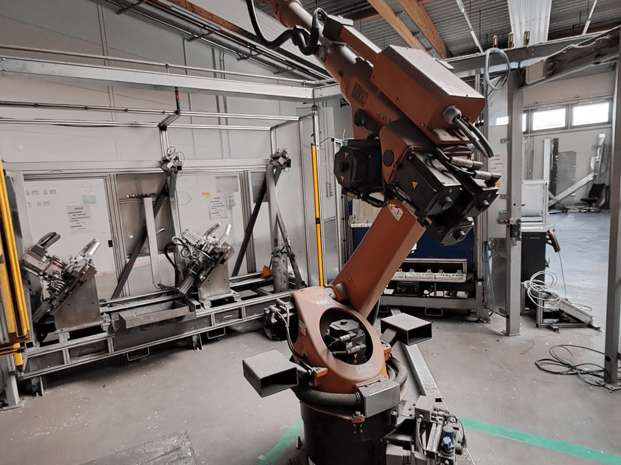 KUKA KR 30L16-2 robota roka rūpnieciskā vidē, skats no sāniem, kurā redzami rokas locītavas un satveršanas rīki.