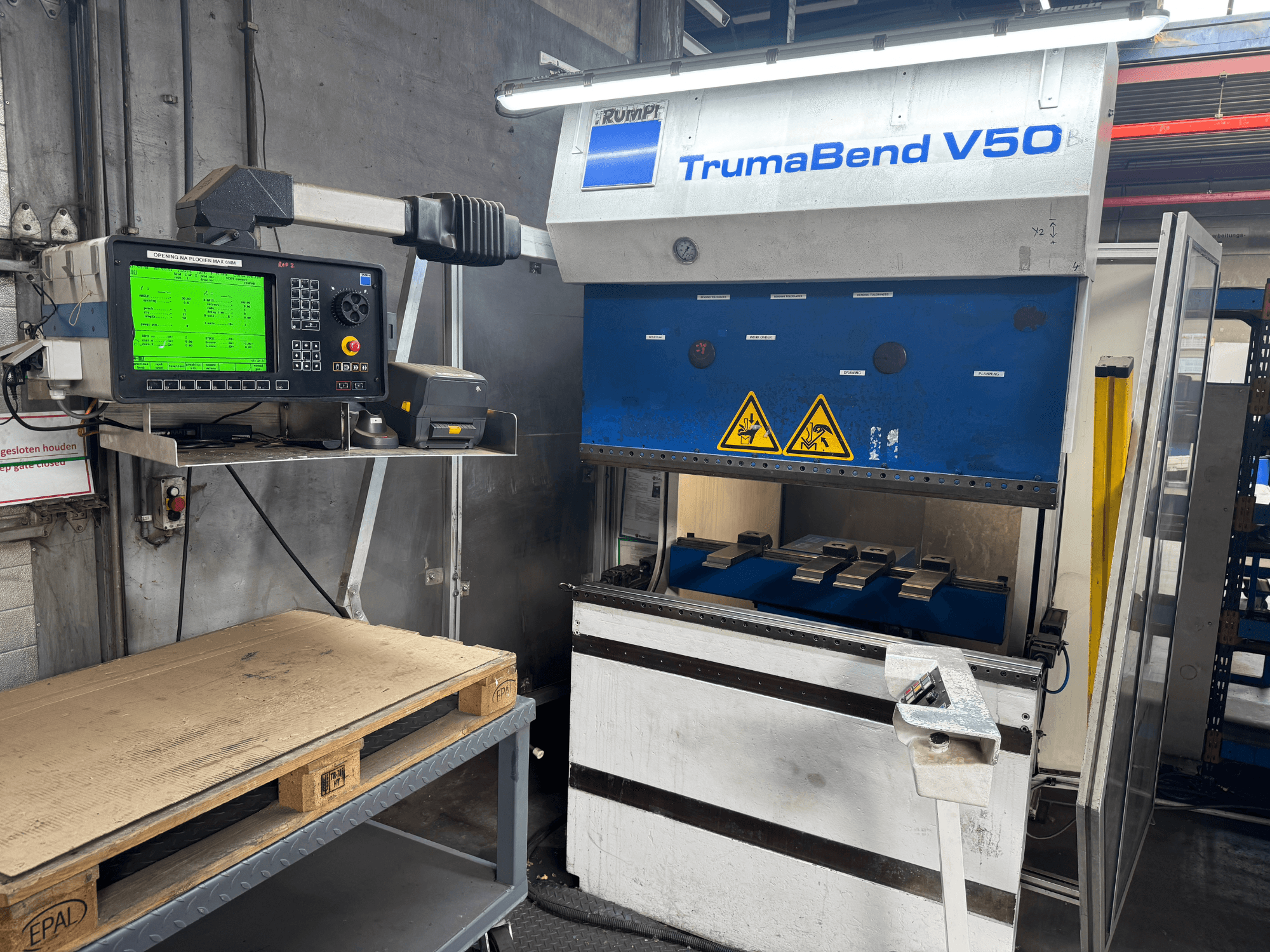 TRUMPF TrumaBend V50 preses bremze, skats no priekšpuses, ar vadības paneli, uz kura redzami iestatījumi un drošības brīdinājuma zīmes.