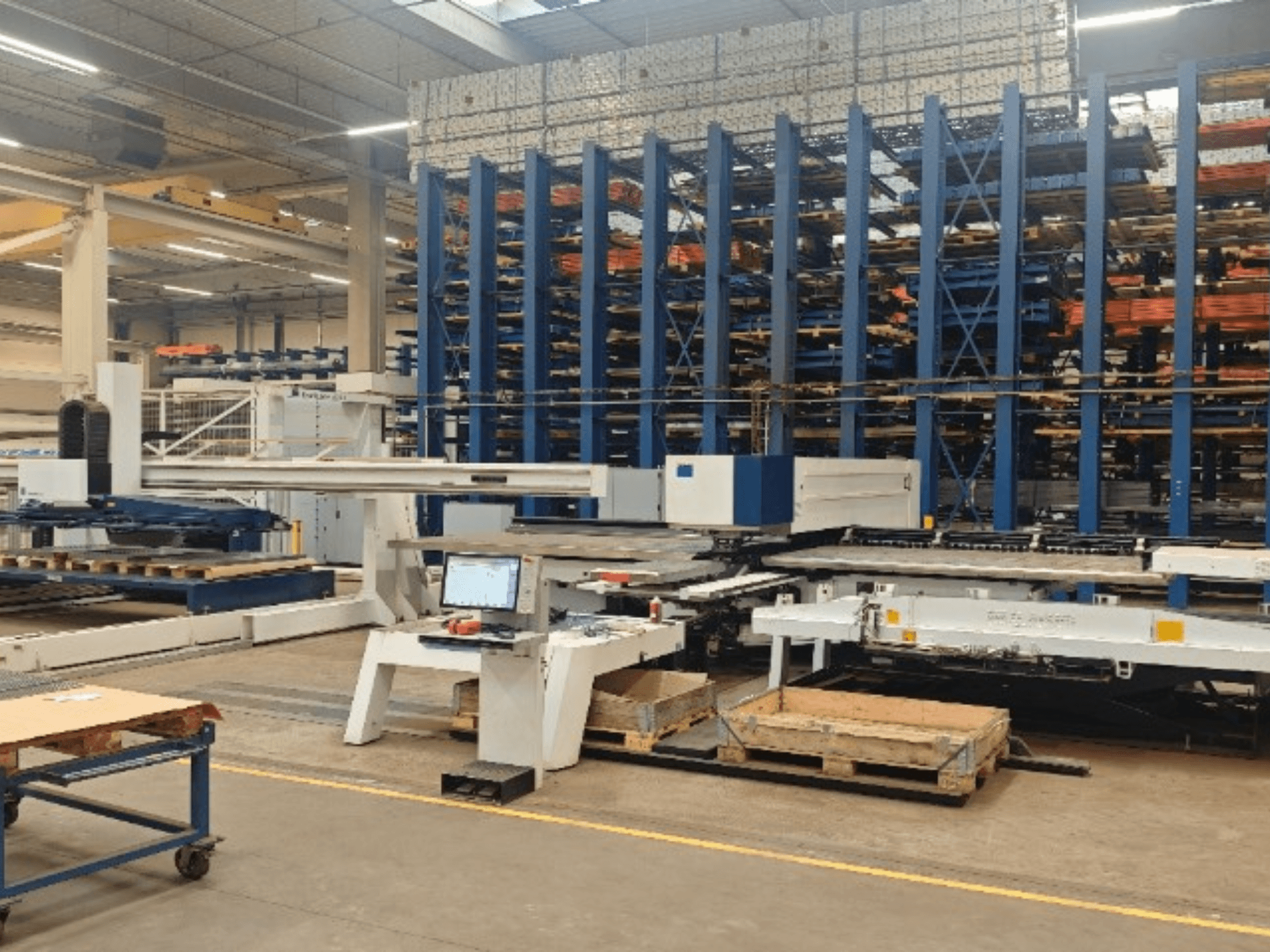 CNC perforācijas mašīna TRUMPF TruPunch 5000 S12 darbnīcā, skats no priekšpuses ar vadības pulti un noliktavas zonu.