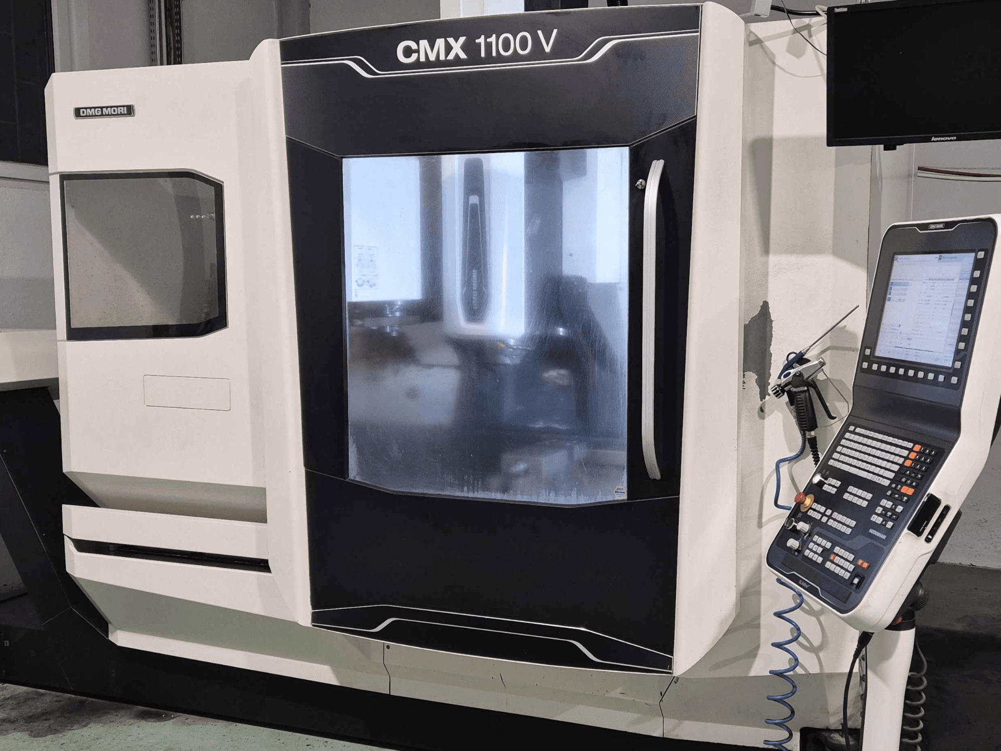 DMG Mori CMX 1100 V, priekšējais skats uz CNC mašīnu ar vadības paneli, digitālo displeju un dzesēšanas šķidruma iestatījumiem.