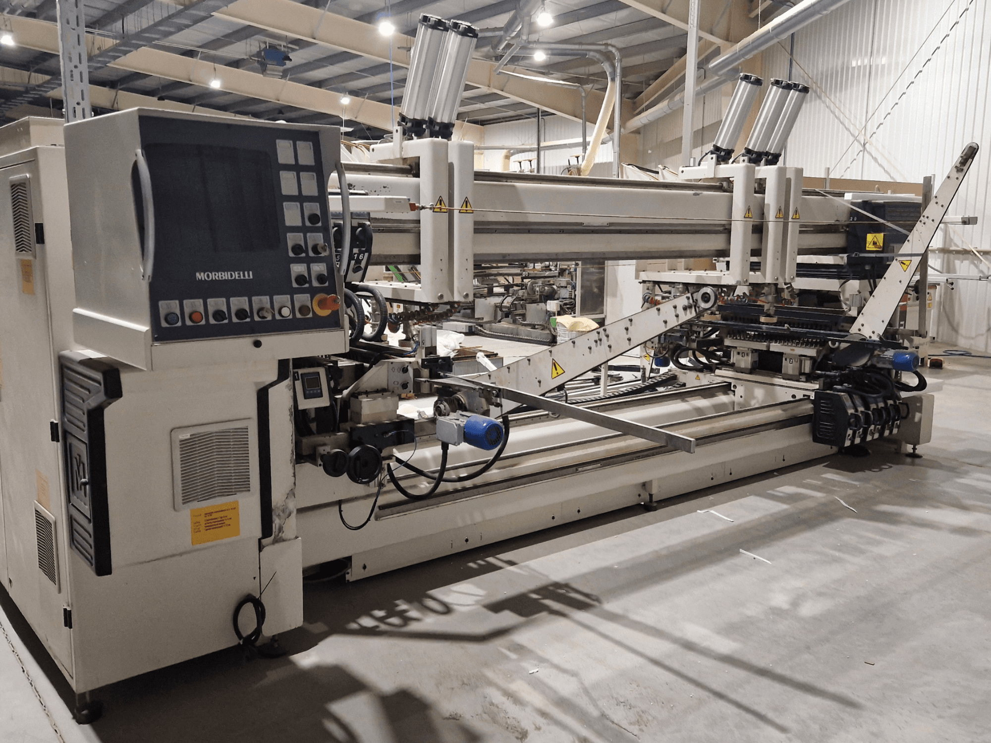 Daudzvārpstu urbjmašīna SCM Morbidelli Zenith F2, sānu skats, kurā redzams vadības panelis un mehāniskās detaļas darbnīcā.