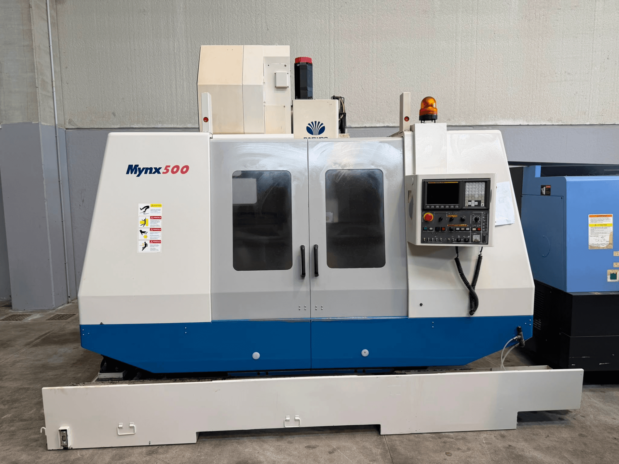 DAEWOO MYNX 500 vertikālais apstrādes centrs, skats no priekšpuses, ar vadības paneli, drošības gaismām un viegli atveramām durvīm.