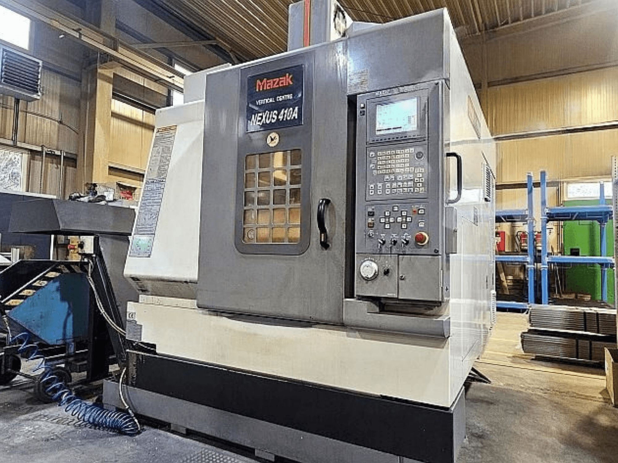 Vertikālais apstrādes centrs „Mazak VCN-410A“ — sānskats, kurā redzams vadības panelis, instrumentu turētājs un darbības funkcijas.