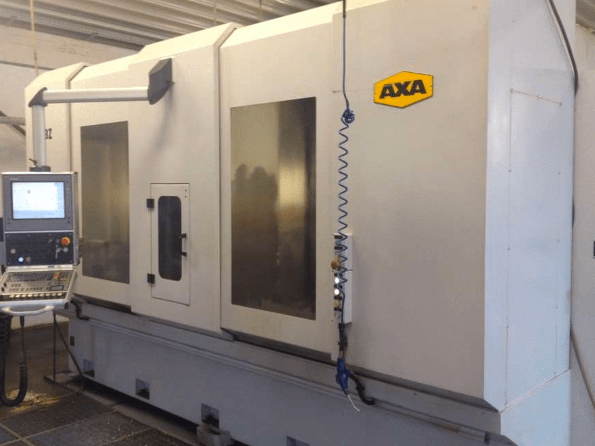 AXA DBZ vertikālais apstrādes centrs no priekšpuses ar vadības paneli un lieliem caurspīdīgiem drošības logiem.