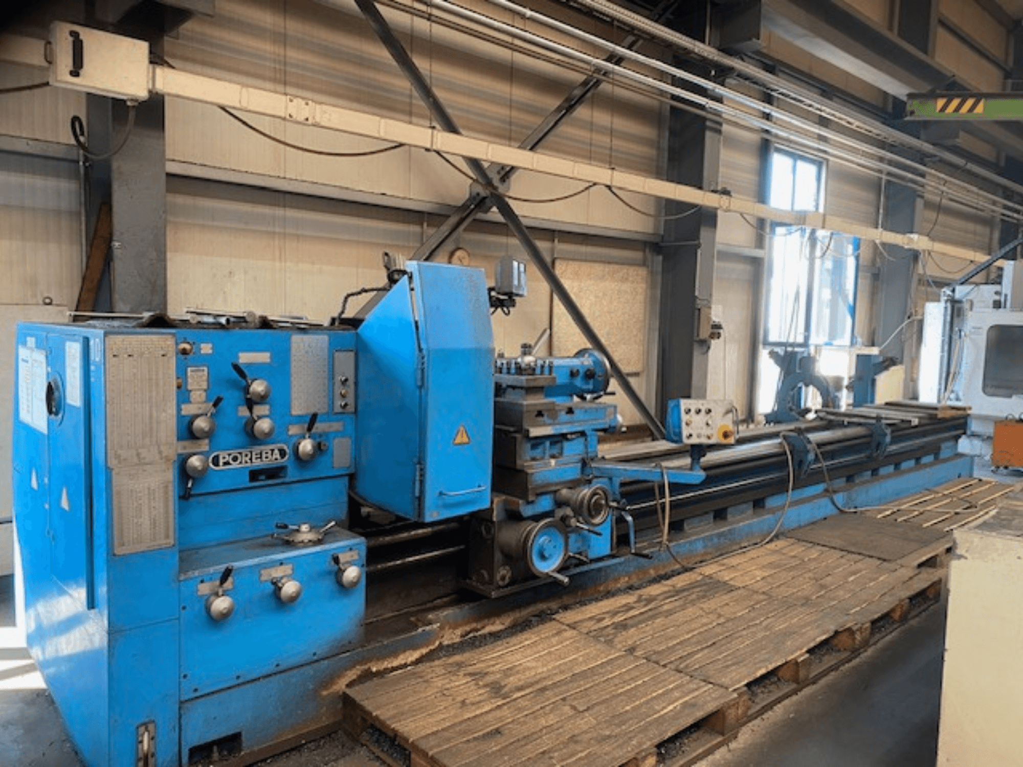 Zilas POREBA virpas priekšējais skats ar vadības pogām, instrumentu paliktni un koka paliktņiem zem tā.