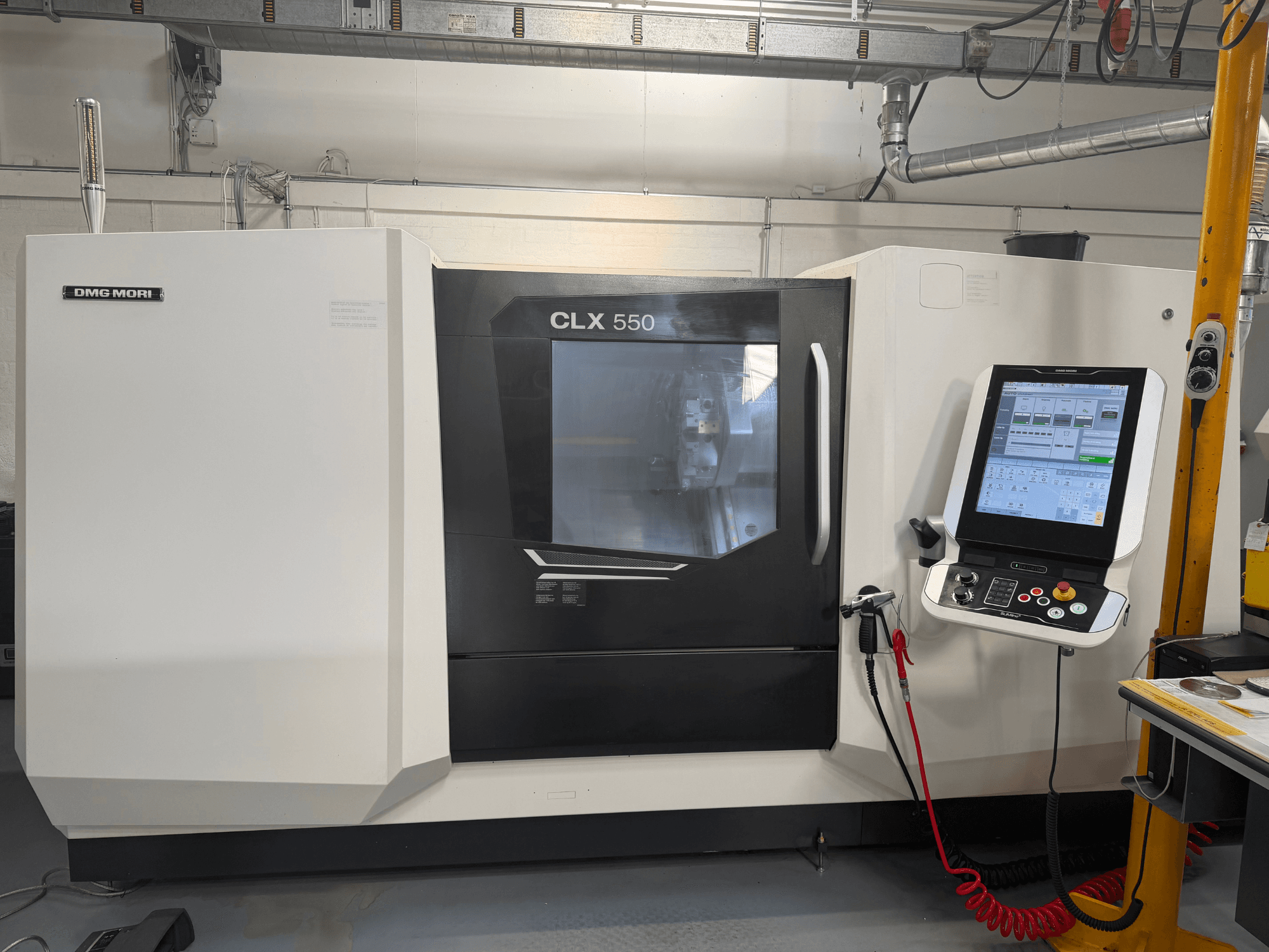 DMG MORI CLX 550 V4 horizontālā virpošanas mašīna, skats no priekšpuses ar vadības paneli un displeju, kas parāda modernās apstrādes funkcijas.