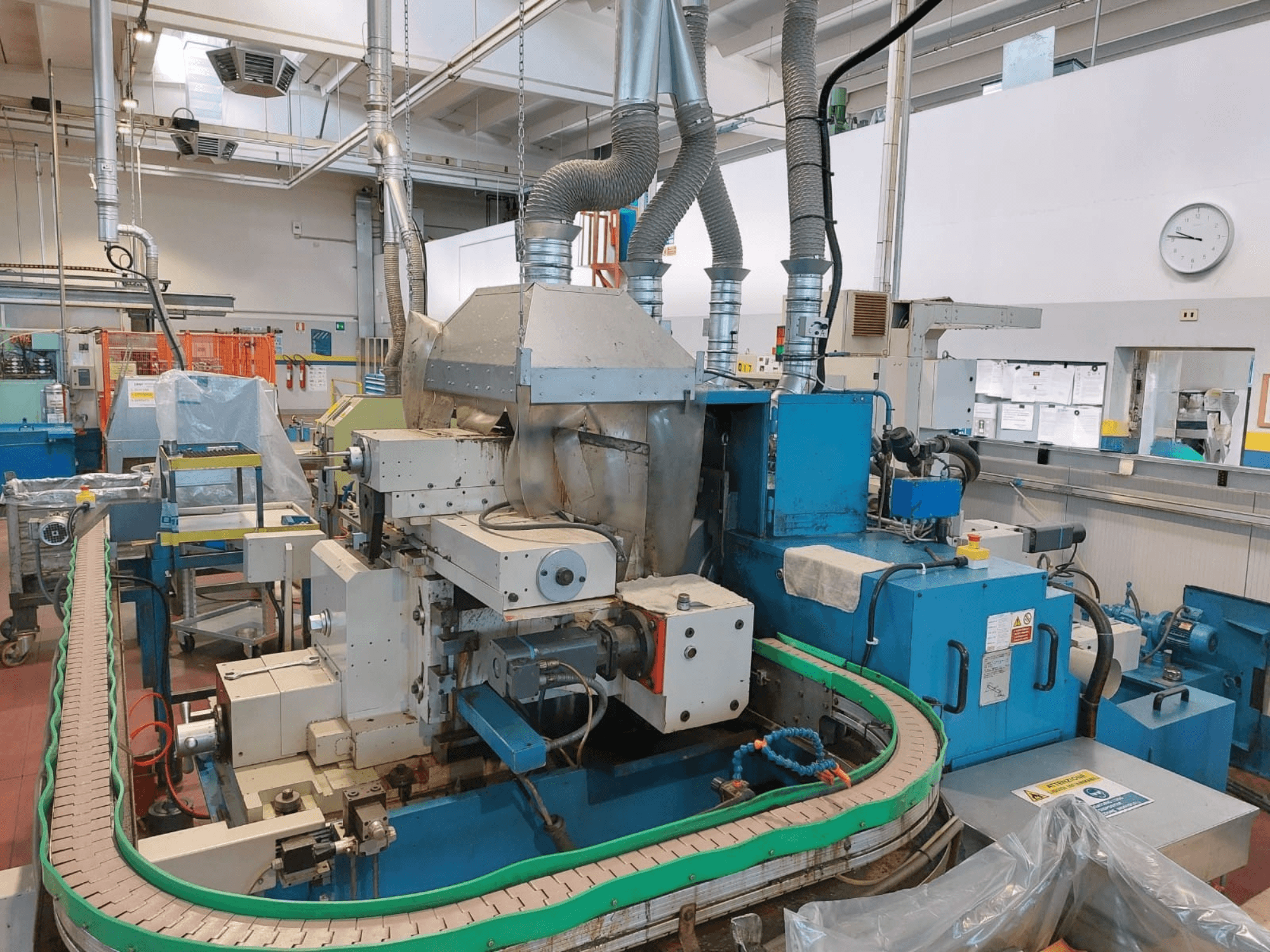 GHIRINGHELLI M300SP610 CNC3A bezcentra slīpmašīna, priekšējais skats, kurā redzamas sarežģītas iekārtas un konveijera detaļas.