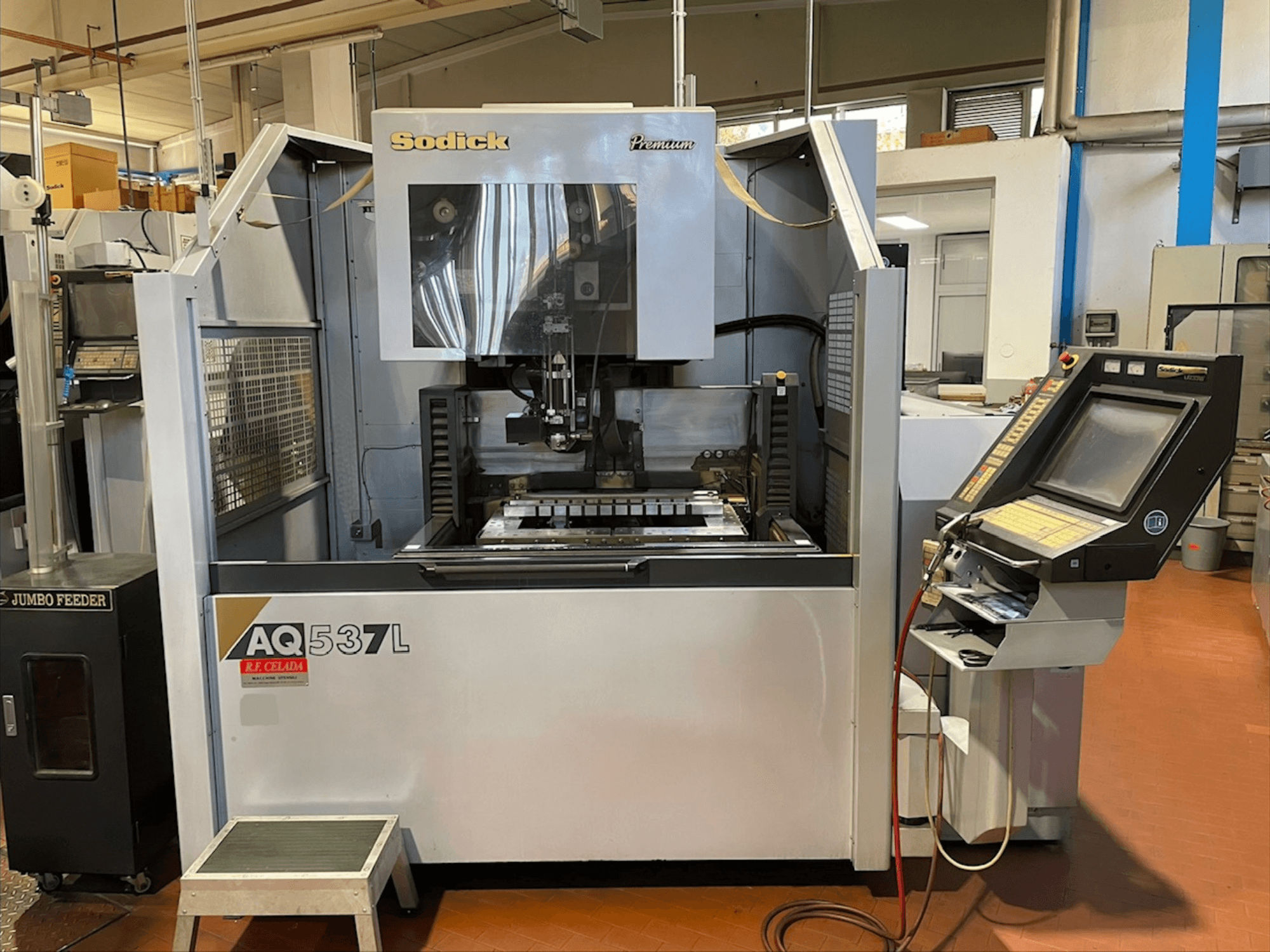 Sodick AQ537L stiepļu EDM mašīna priekšpusē, kurā redzams vadības panelis un apstrādes zona ar redzamajiem komponentiem.
