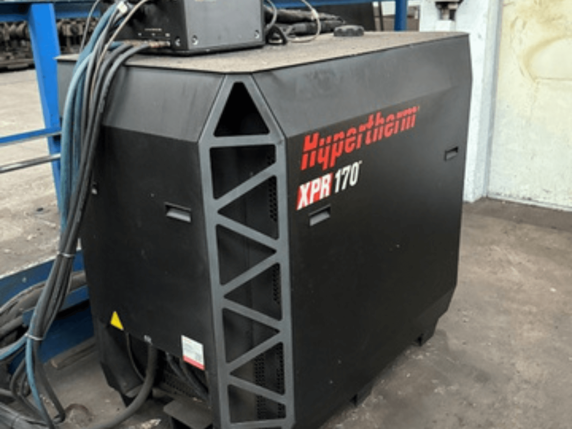 Hypertherm XPR170 plazmas griezējs, skatīts no sāniem, ar dzesēšanas atverēm un vairākiem ekspluatācijas kabeļiem.