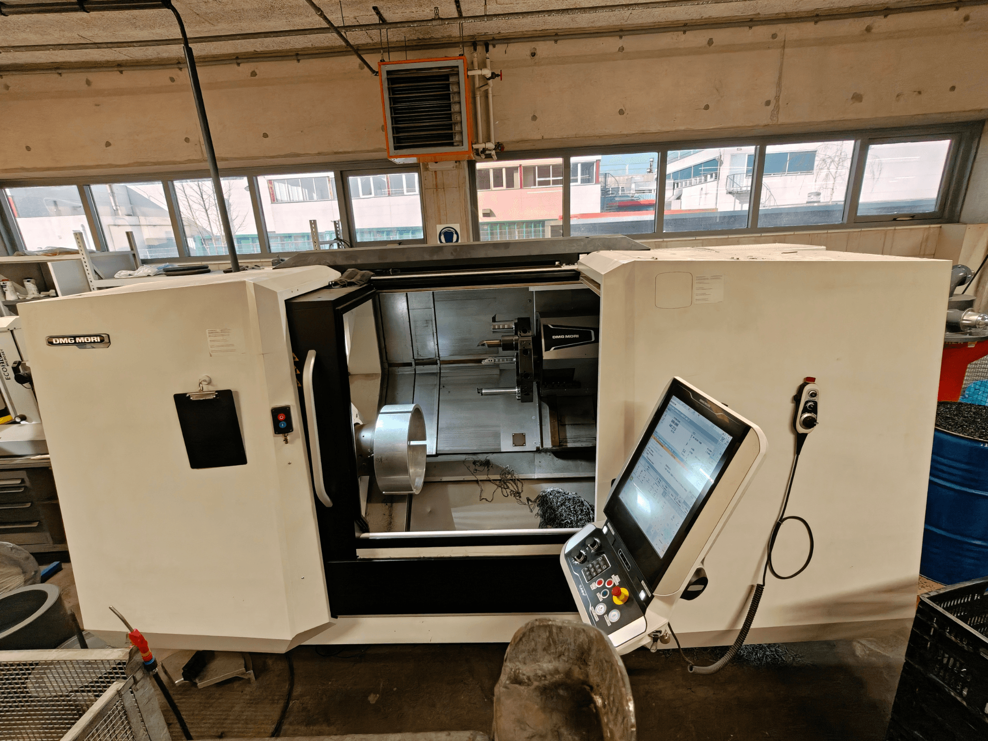 DMG MORI CLX 550 horizontālās virpošanas mašīnas priekšējais skats, kurā redzams vadības panelis un atvērta darba zona.