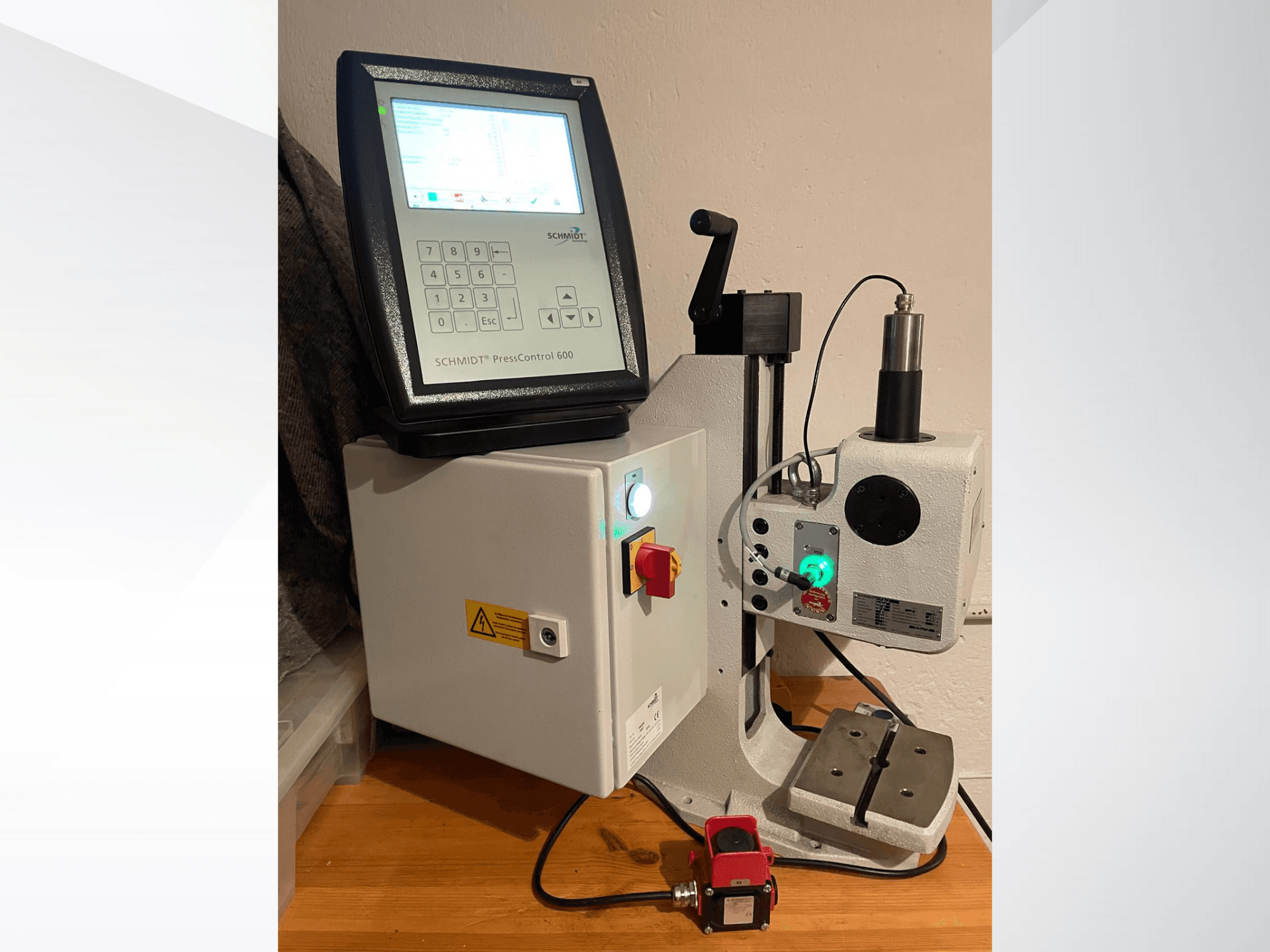 SCHMIDT® PressControl 600, priekšējais skats, kurā redzams vadības panelis, ieslēgšanas poga un hidrauliskā prese ar drošības funkcijām.