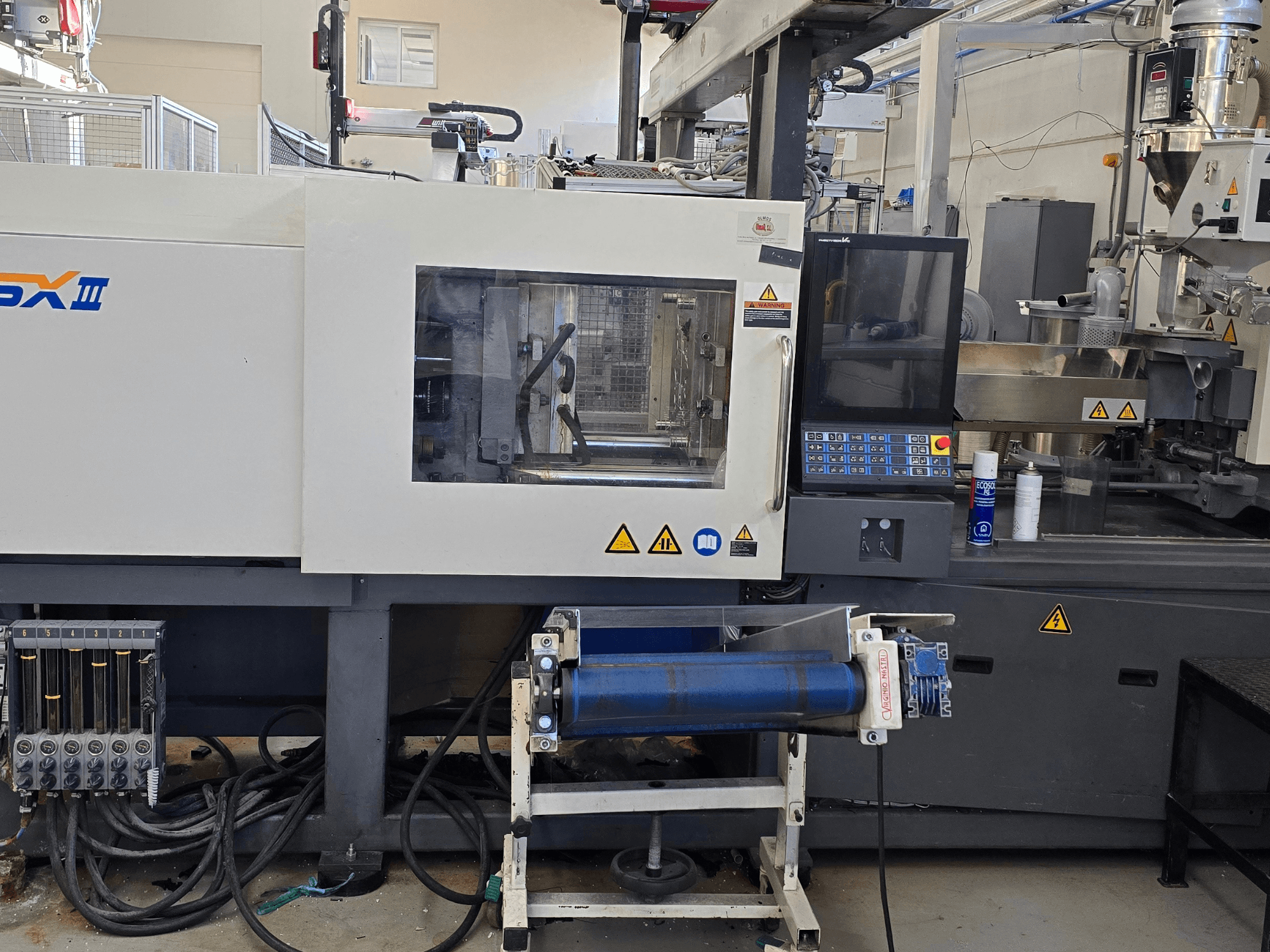 SHIBAURA EC130SXIII-4A elektriskā iesmidzināšanas iekārta, priekšējais skats, vadības panelis un hidrauliskie komponenti.