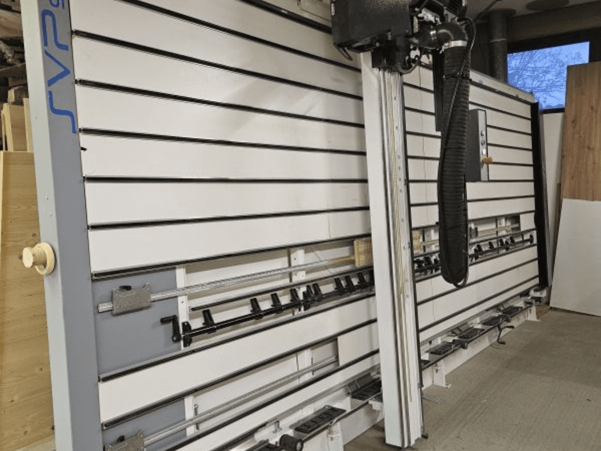 SVP bīdāmie paneļu zāģi darbnīcā, skats no priekšpuses, ar regulējamām sliedēm un augšējo putekļu nosūces sistēmu.