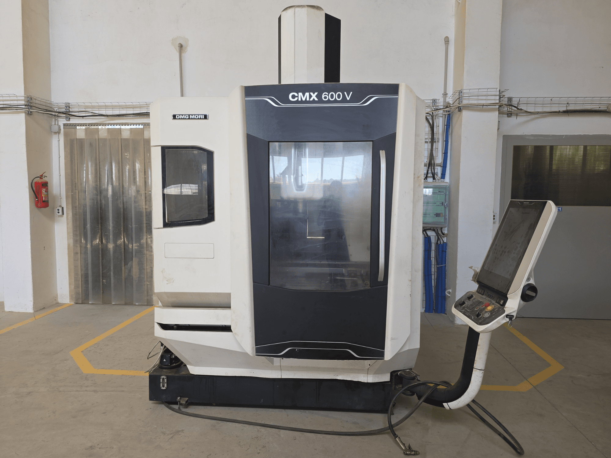 DMG MORI CMX 600 V vertikālais apstrādes centrs, skats no priekšpuses, ar vadības paneli un lielu caurspīdīgu logu.