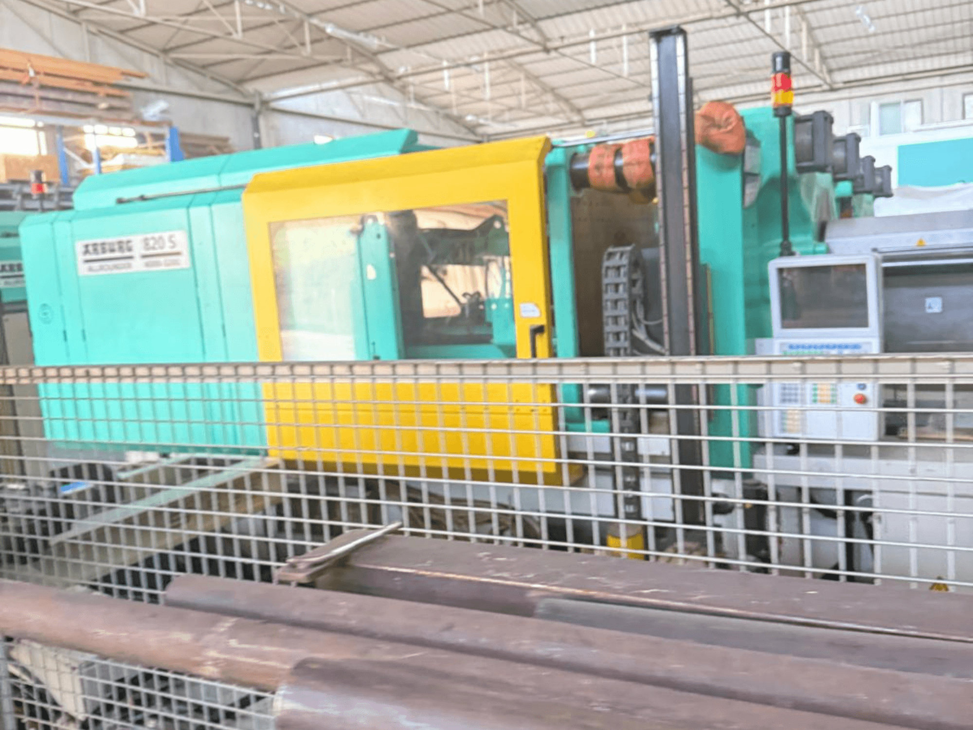 Hidrauliskā iesmidzināšanas iekārta Arburg SELECTA 820 S 4000-3200, skats no sāniem, redzams vadības panelis un spilgts dzeltens un tējas krāsas dizains.