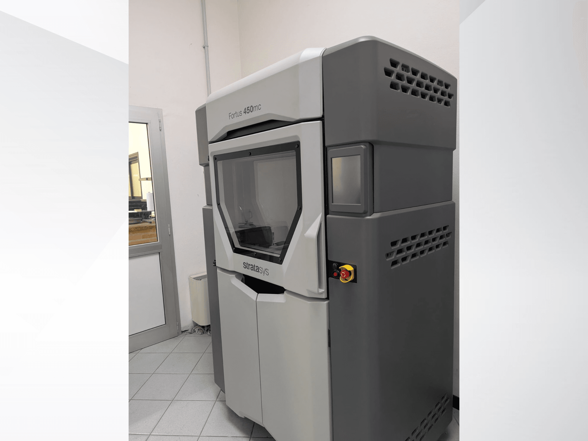 Stratasys FORTUS 450mc plastmasas 3D printeris no sānu skata, kurā redzams glīts dizains un vadības panelis.