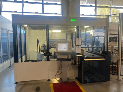 Rūpnieciskās lieces mašīnas, modelis Piegatrice 3, priekšējais skats ar vadības paneli un robotizēto roku, labi apgaismotā darbnīcā.