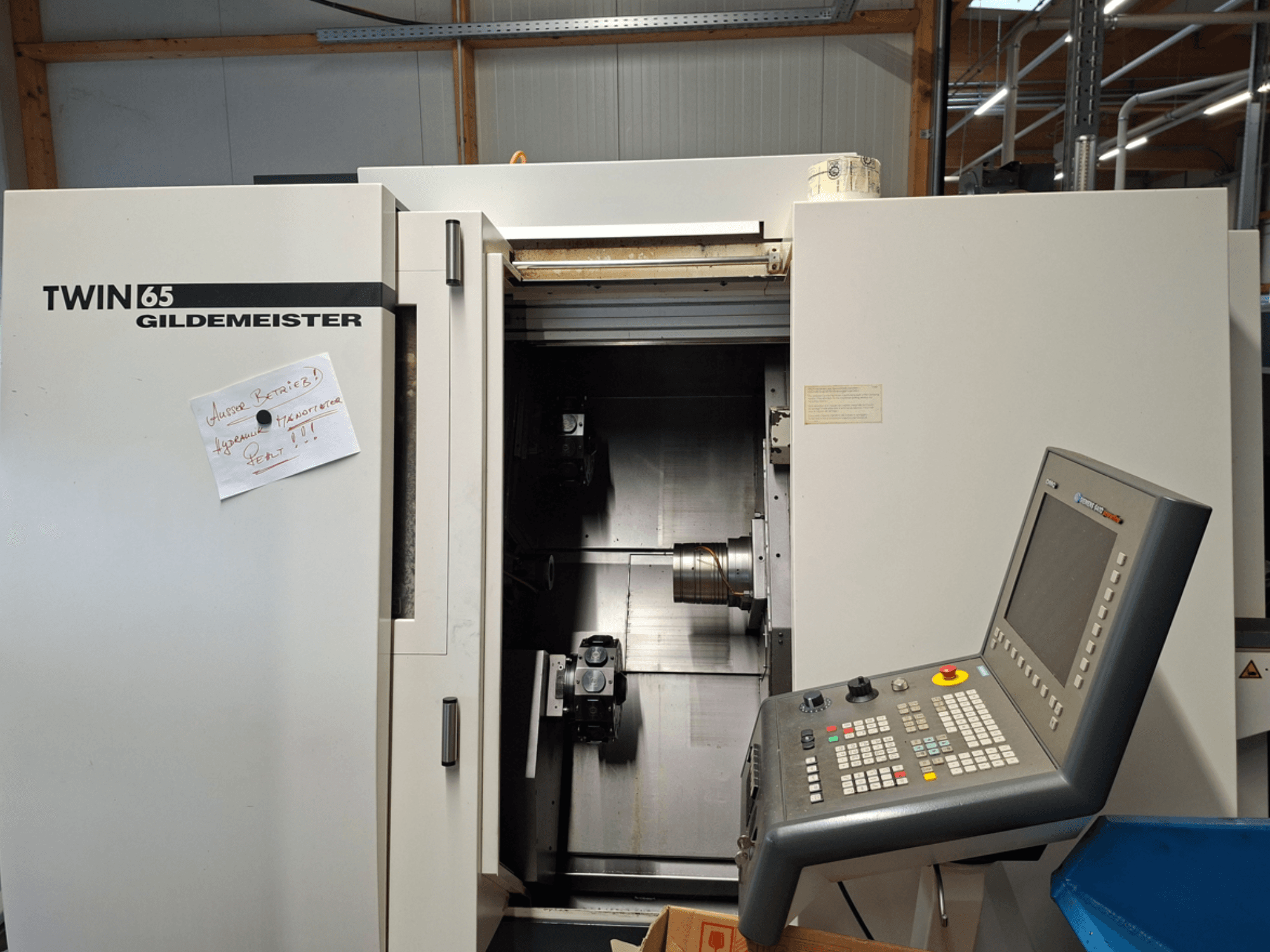 Gildemeister TWIN 65 CNC virpa, priekšējais skats, kurā redzams vadības panelis un daļēji atvērta kamera ar redzamām iekārtām.
