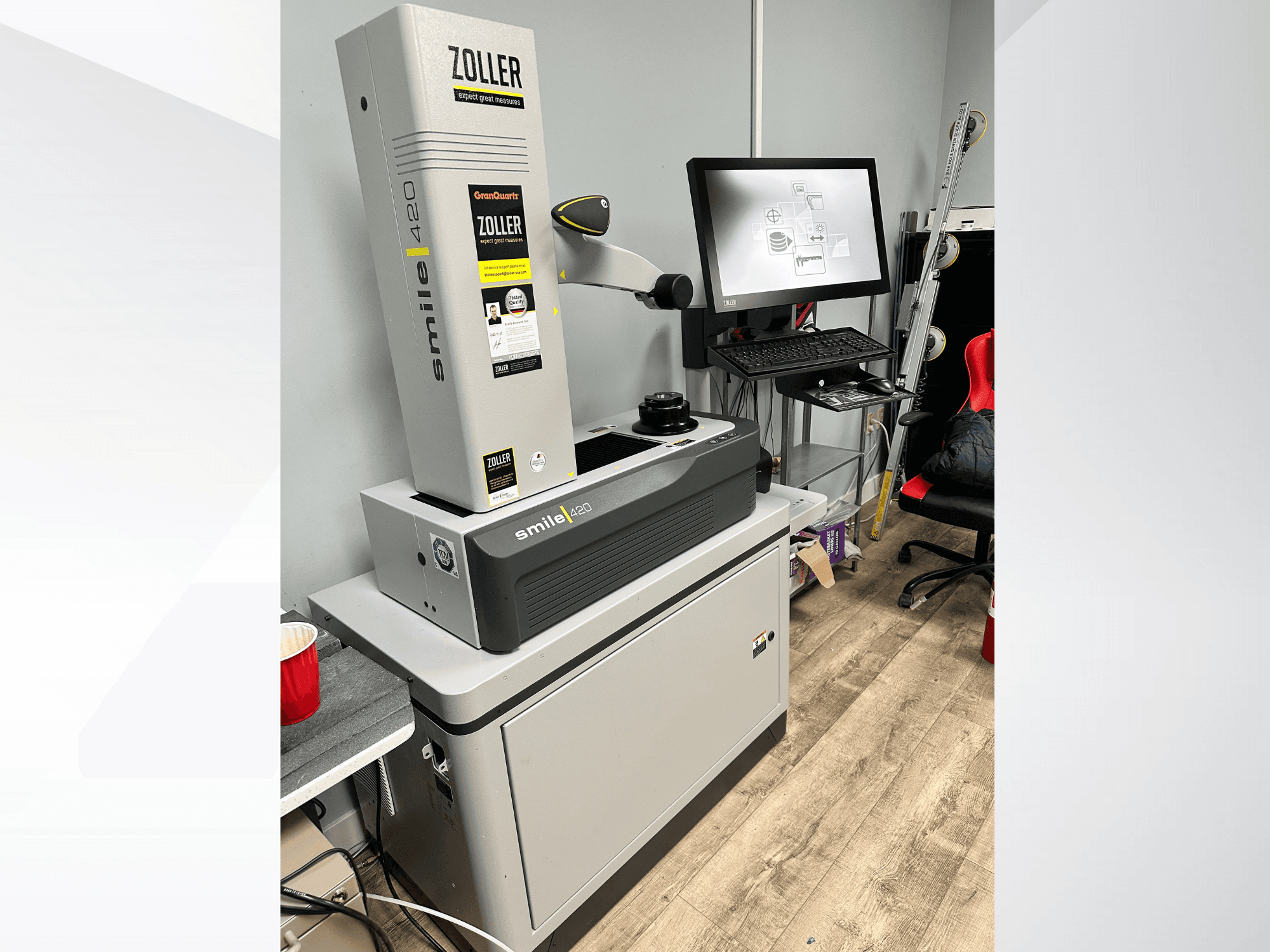 Digitālā mērīšanas iekārta Zoller Smile 420, kas parādīta priekšpusē ar monitoru un darba vietu fonā.