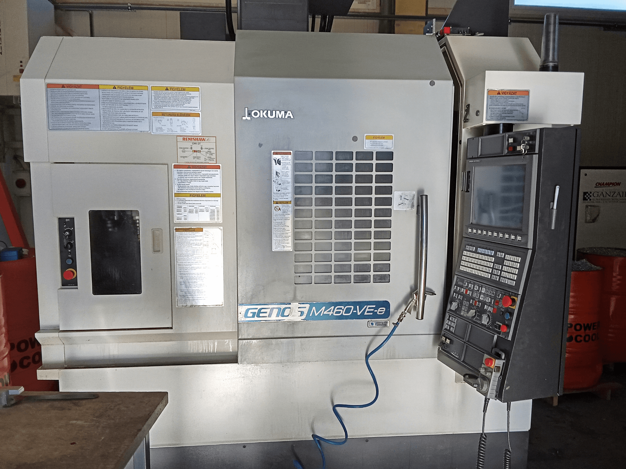 Okuma M460R-VE vertikālais apstrādes centrs, priekšējais skats, kurā redzams vadības panelis un operatīvās saskarnes detaļas.