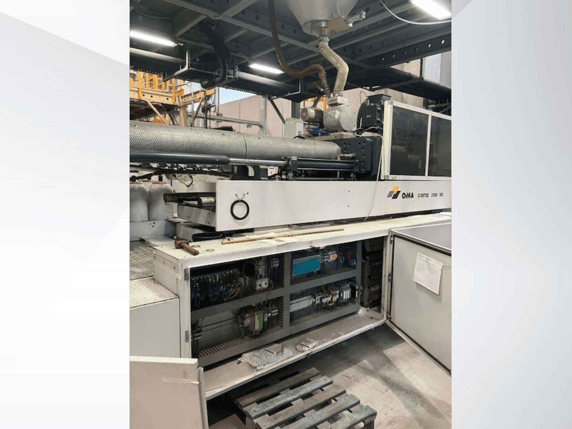 OMA ekstrūdera 3500 priekšējais skats, kurā redzamas darbības daļas, vadības panelis un elektroinstalācijas detaļas. Smagā tehnika rūpnieciskā vidē.