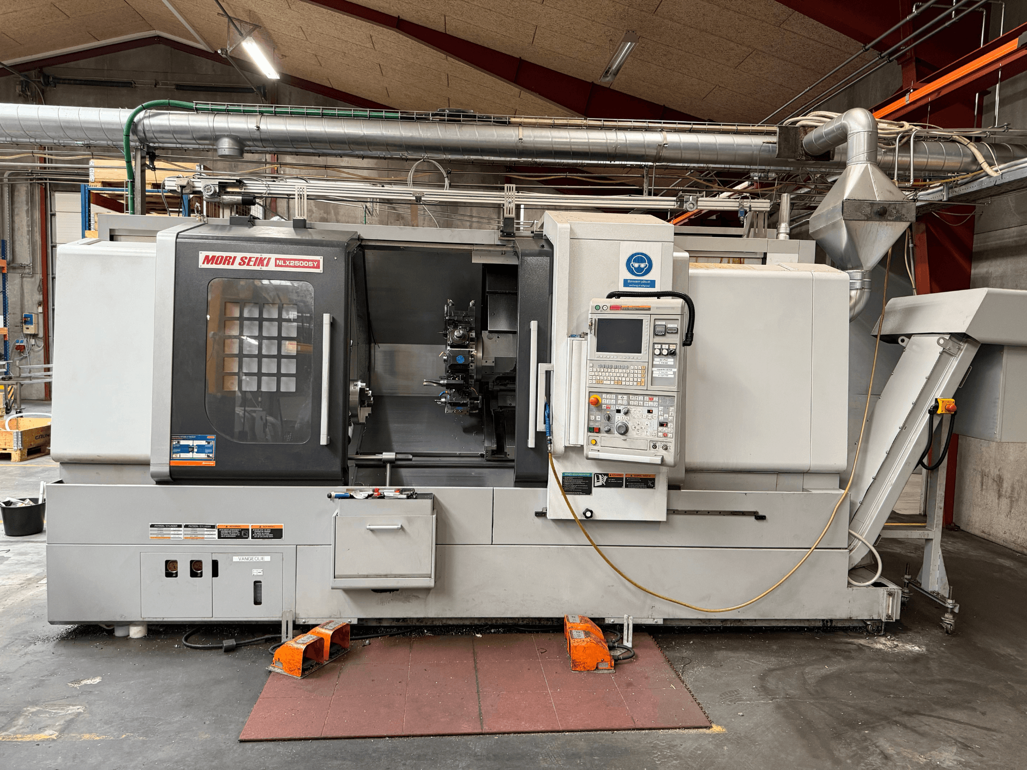 DMG MORI NLX2500SY/1250 horizontālā virpošanas mašīna, skats no priekšpuses, kurā redzams vadības panelis un darba komponenti.