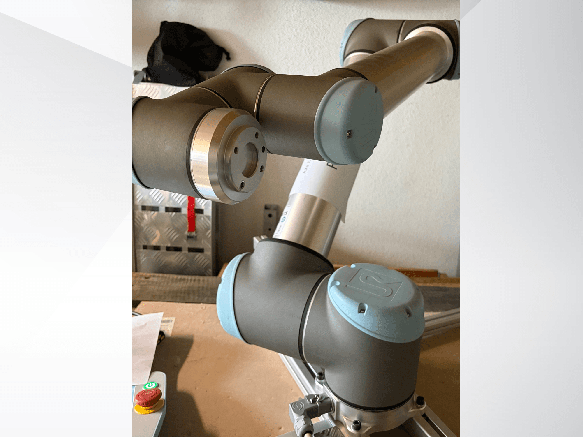 Robotizētās rokas Universal Robots UR10 tuvplāna skats no sāniem, izceļot locītavas un pelēkzilus dizaina elementus.