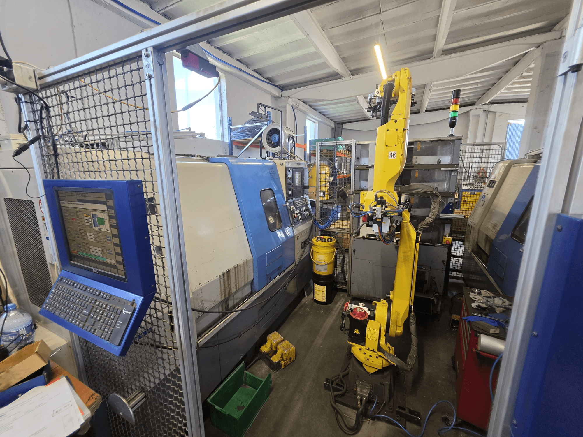 „Hyundai HIT-200C“ horizontālā virpošanas mašīna ar FANUC M-20iA robotu; skats no priekšpuses, kurā redzama vadības saskarne un iekārtas konfigurācija.