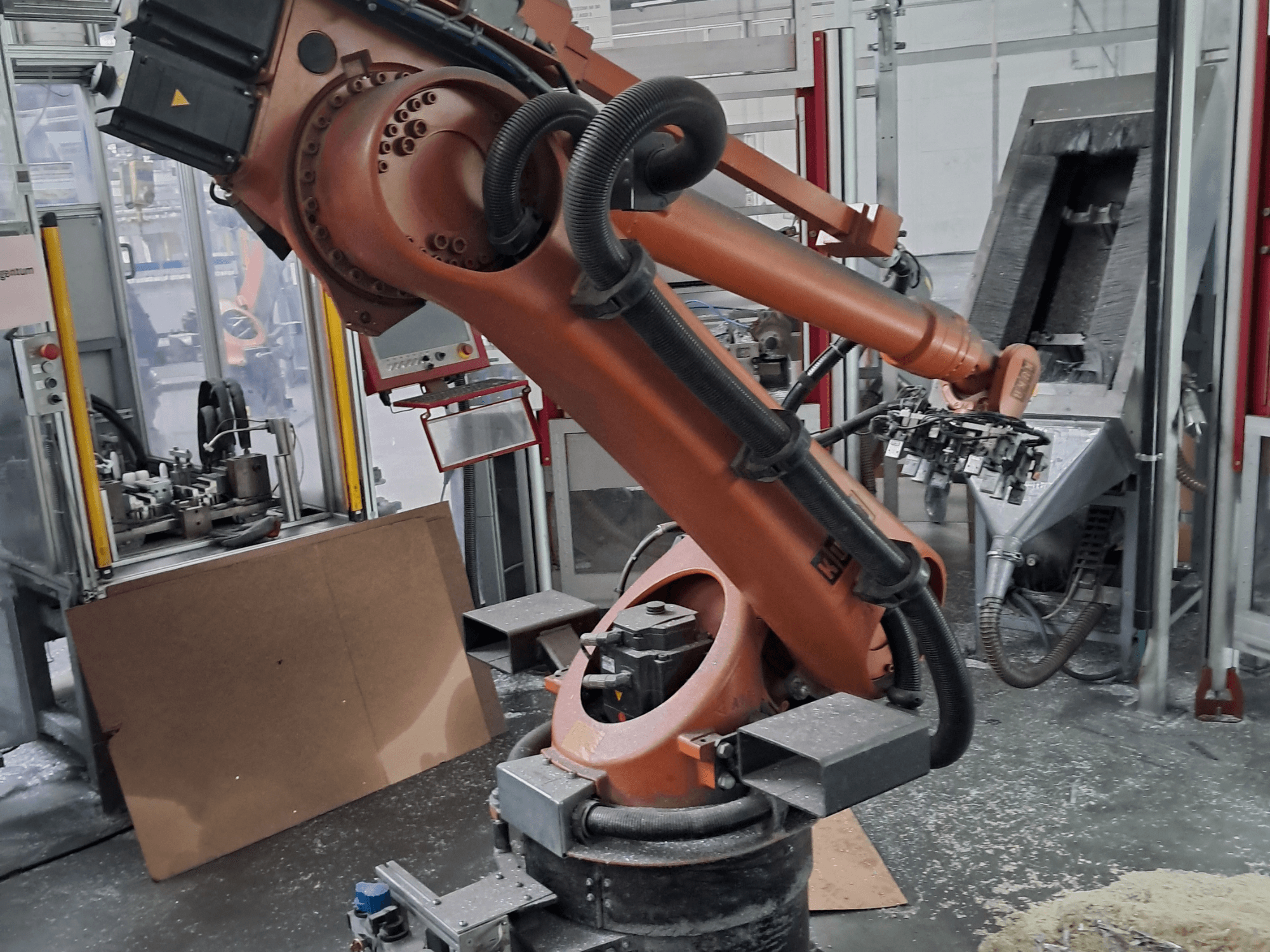 KUKA KR 30 L 16-2 robota roka darbnīcā, skats no priekšpuses. Attēlā redzami šarnīrveida savienojumi un rūpnieciskas darba vides fons.