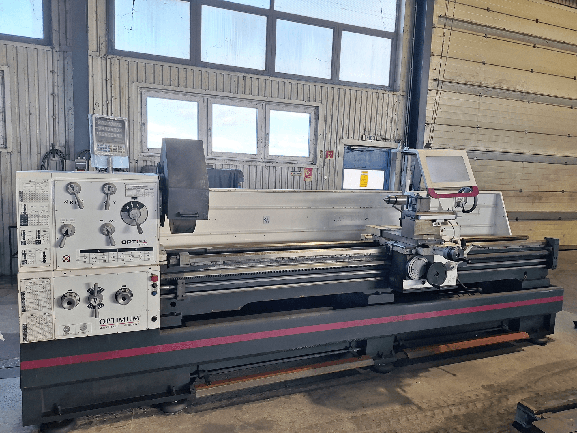 Optimum OptiTurn TH 8030D horizontālās virpošanas darbgalds sānu skatā, ar vadības paneli, instrumentu turētāju un izturīgu pamatni.