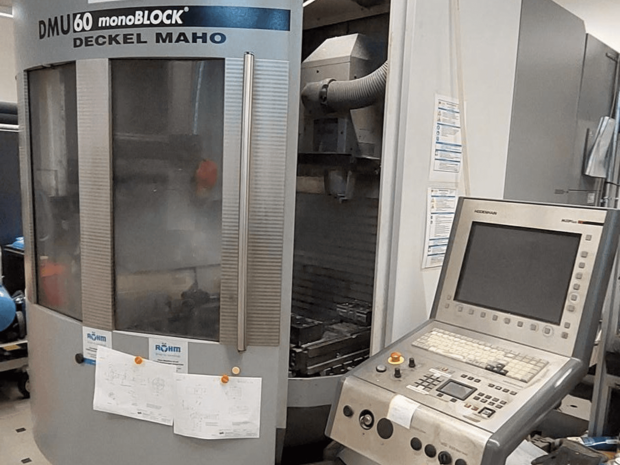 DMU 60 monoBLOCK, Deckel Maho, CNC frēzmašīnas priekšējais skats ar vadības paneli un pievienotiem tehniskajiem rasējumiem.