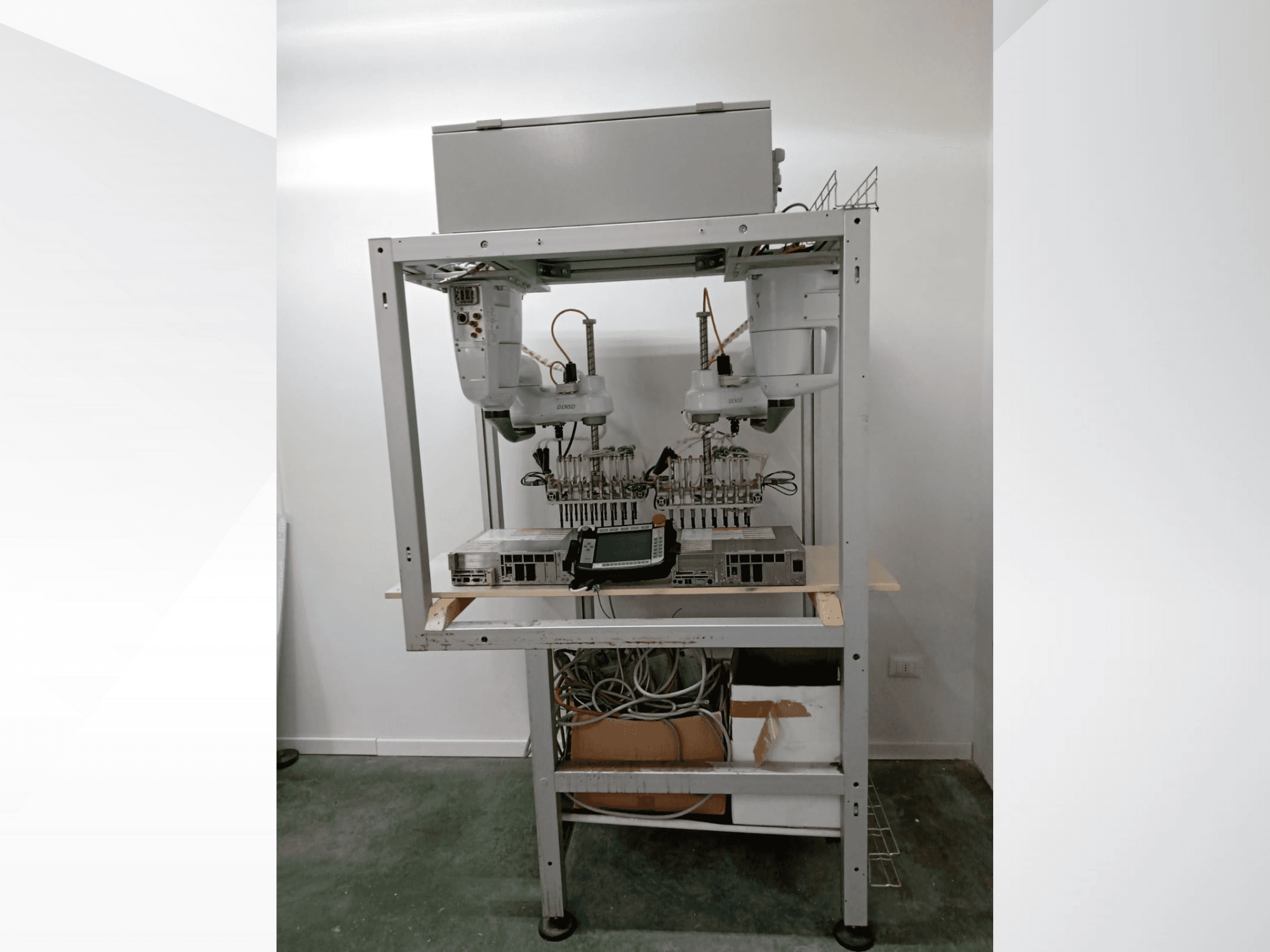 Automatizēta robotizēta darbstacija ar divām rokām, displeja bloku un elektroniku uz metāla rāmja, skats no priekšpuses, uzlabotas tehnoloģijas uzstādīšana.