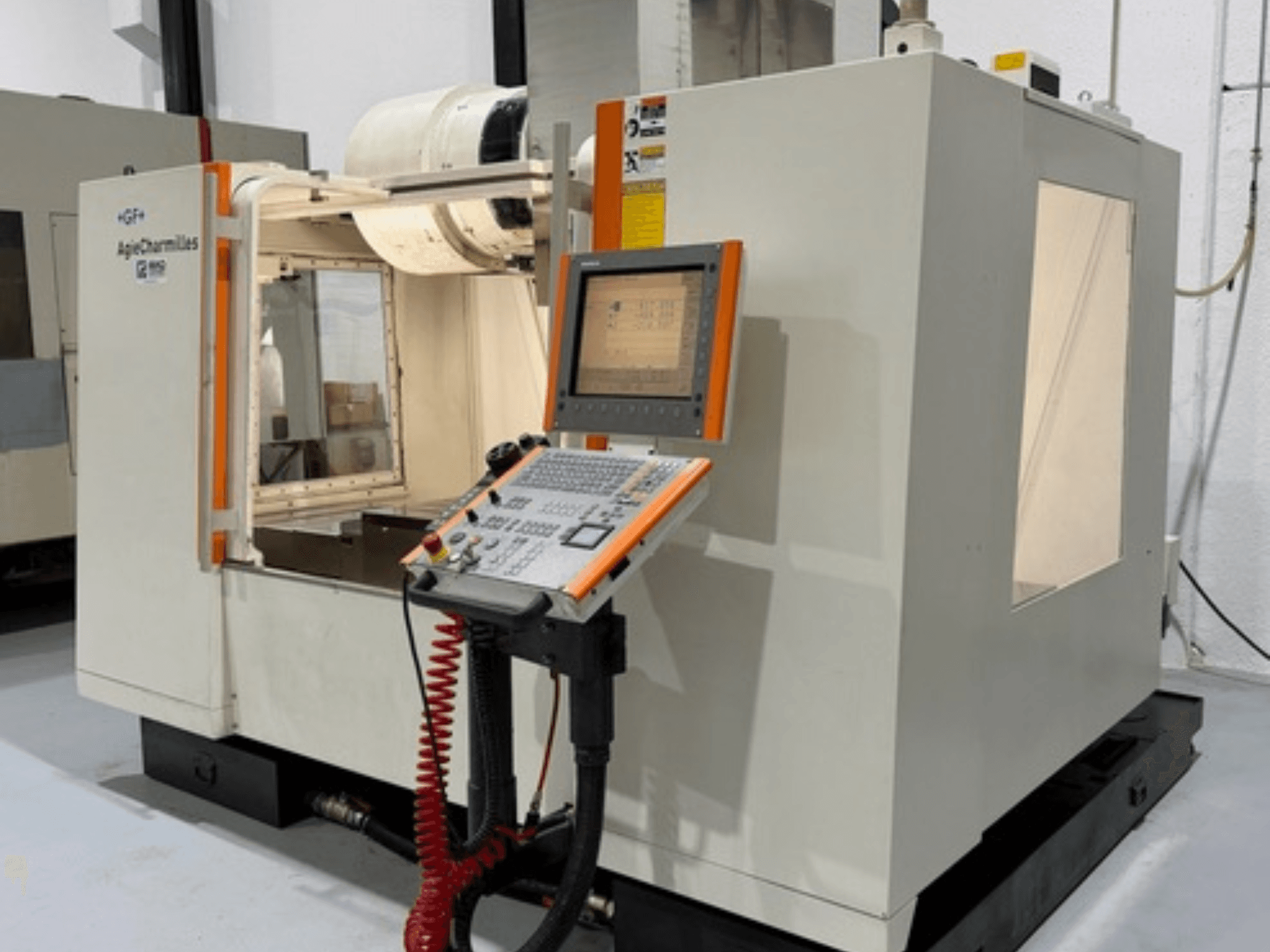 GF AgieCharmilles MIKRON frēzmašīna sānu skatā, ar vadības paneli ar pogām un displeja ekrānu.