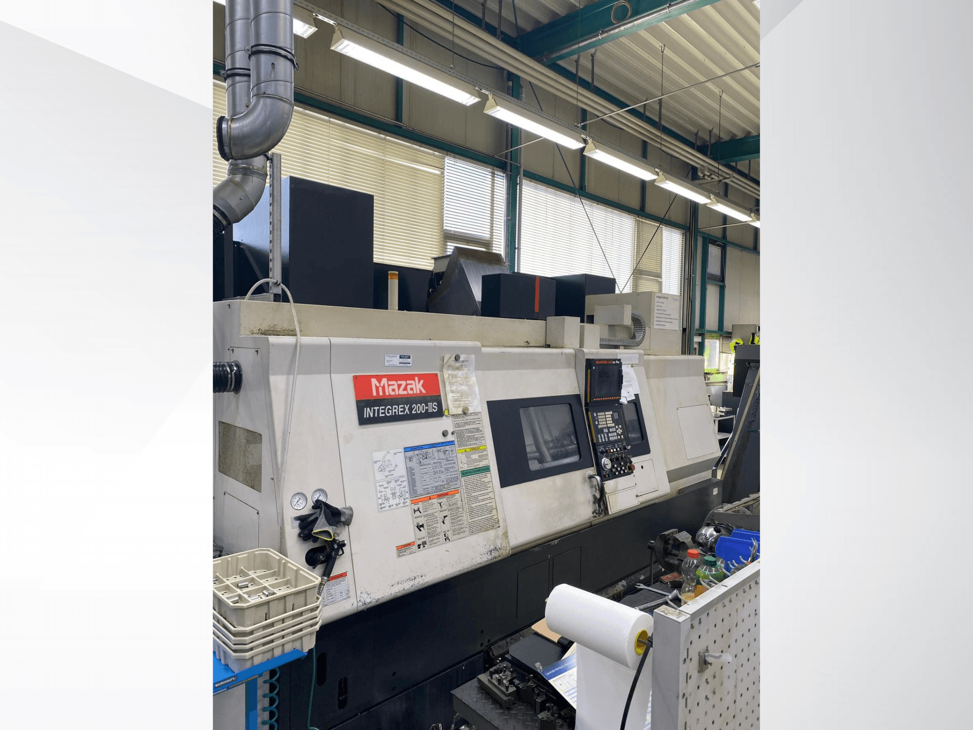 Mazak INTEGREX 200 III S virpošanas un frēzēšanas centrs, skats no sāniem, kurā redzams vadības panelis, mērinstrumenti un darba zonas instrumenti.