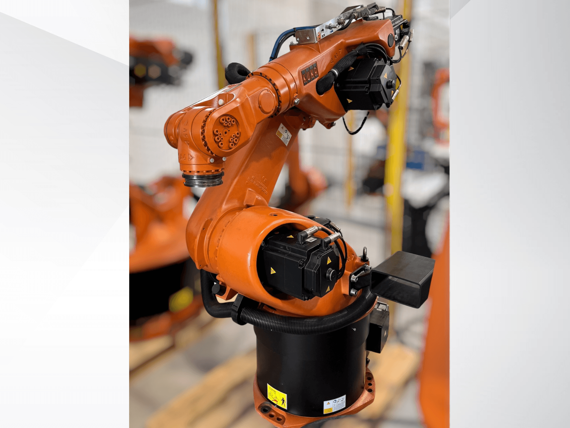 KUKA KR 60-3 robota roka oranžā krāsā; sānu skats, kurā redzama bāze, locītavas un vadības moduļi automatizācijas uzdevumiem.