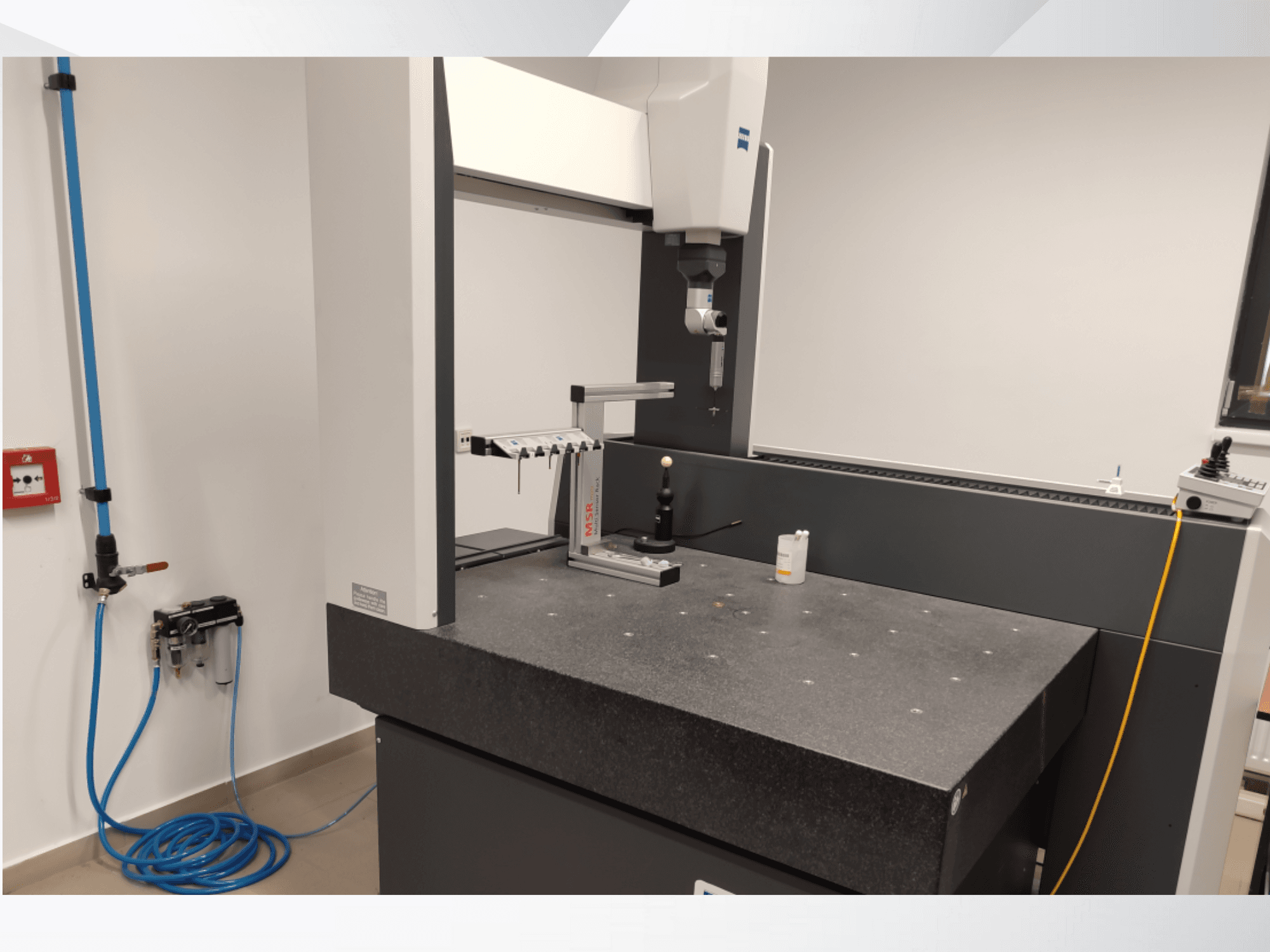 MSR mērierīce laboratorijā, priekšējais skats, kurā redzams granīta galds, kalibrēšanas sfēra un pieslēgtie palīgrīki.