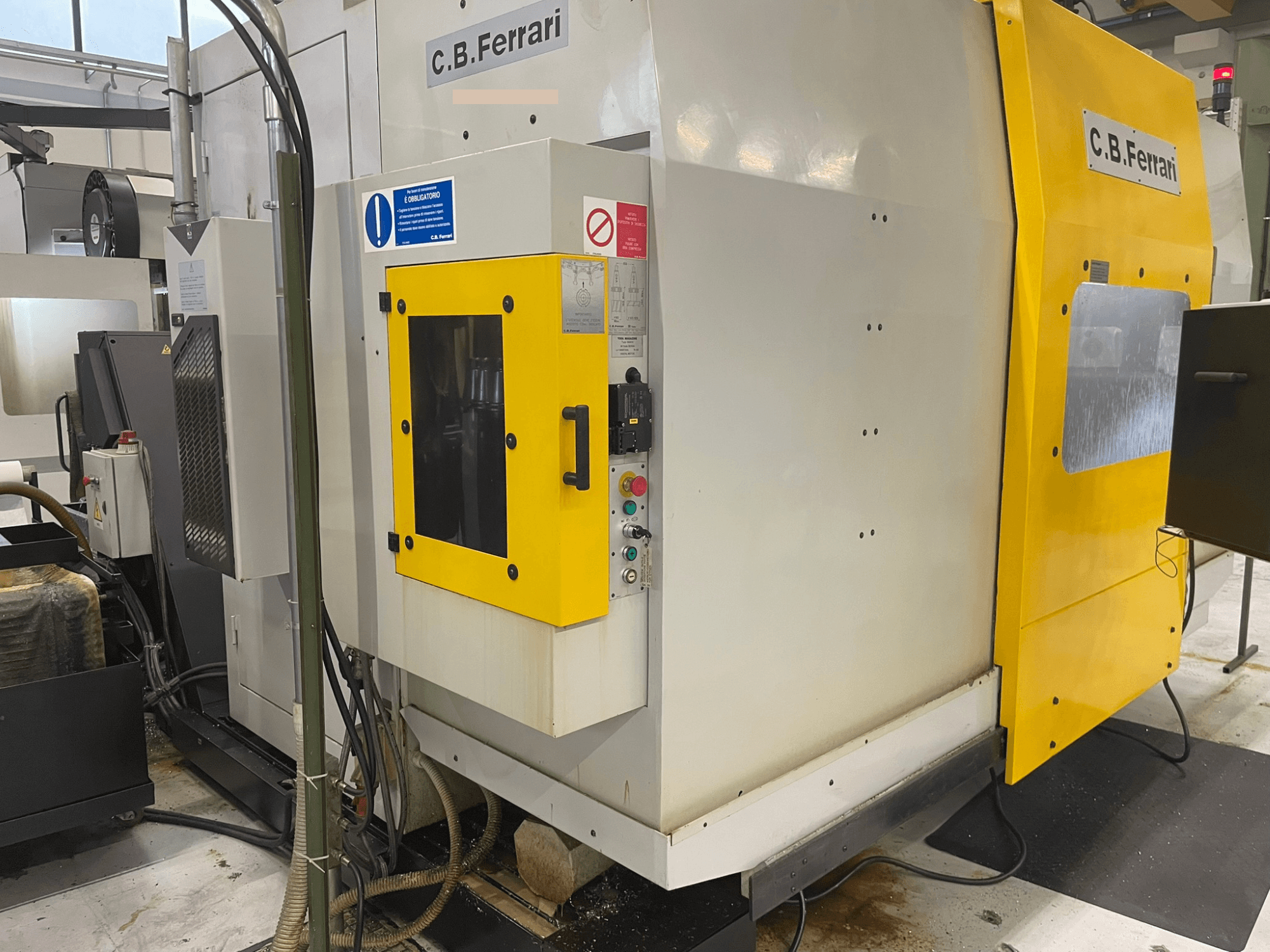 C.B. Ferrari industriālā mašīna, skats no priekšpuses; dzeltenas durvis, vadības panelis un redzami apstrādes komponenti.
