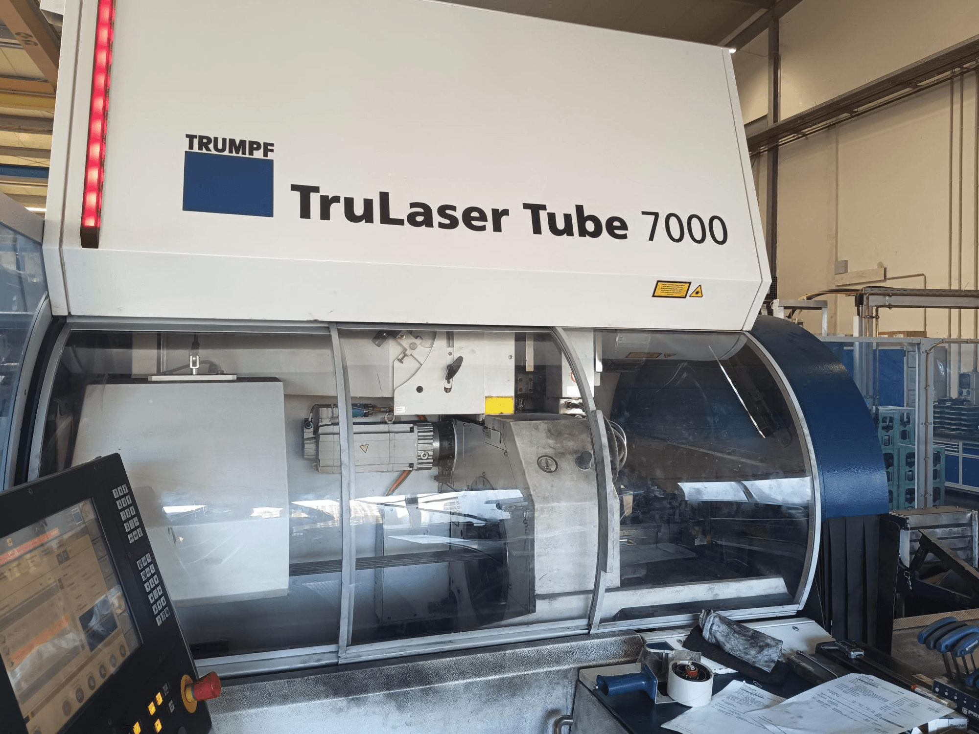 TRUMPF TruLaser Tube 7000, priekšējais skats uz iekārtu ar vadības paneli, kurā redzamas lāzera griešanas funkcijas un darba telpa.