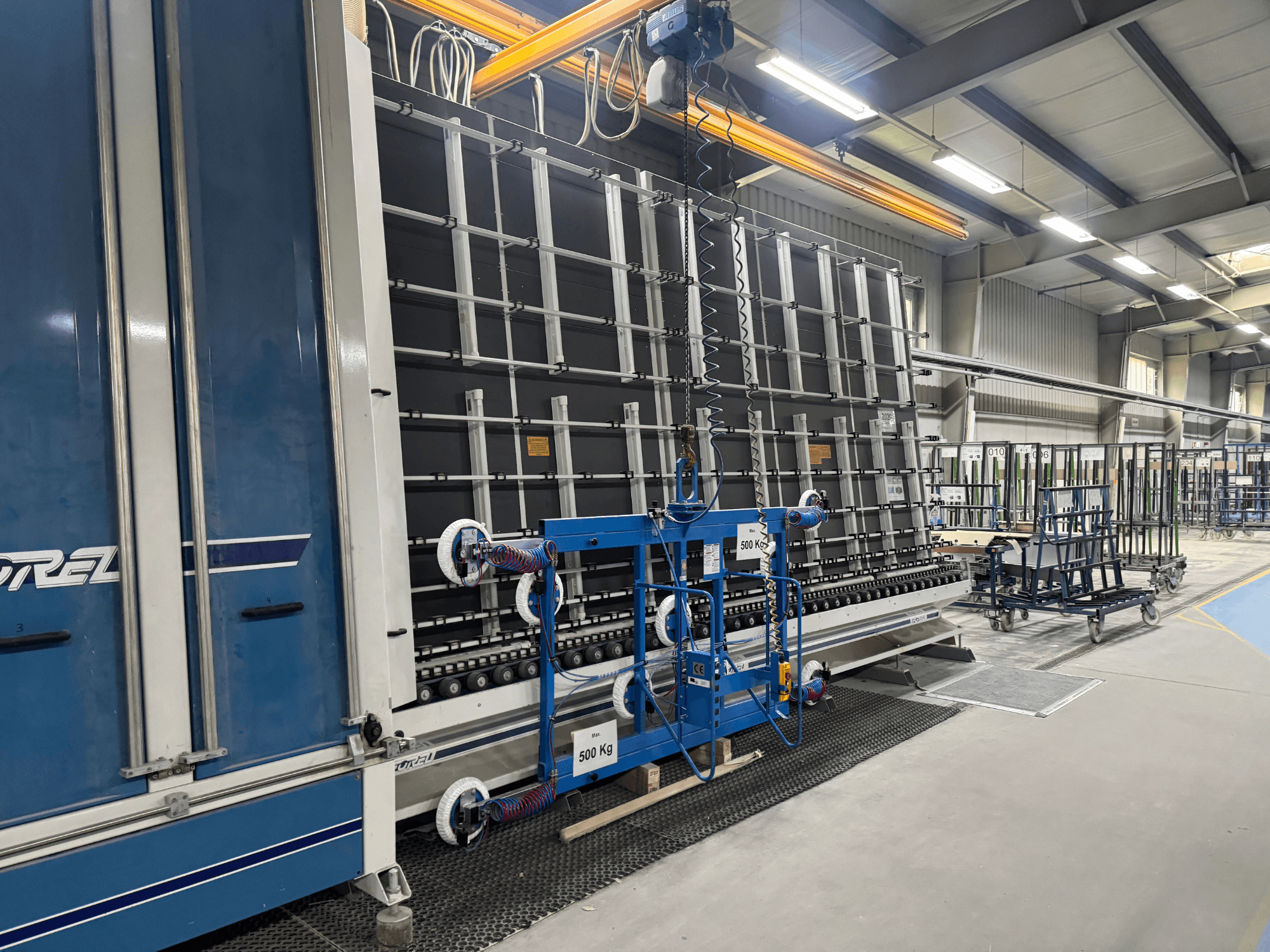 Drel rūpnieciskās iekārtas ar lielu rāmi un pacelšanas mehānismu, kas parādītas no sānu skata rūpnīcā.