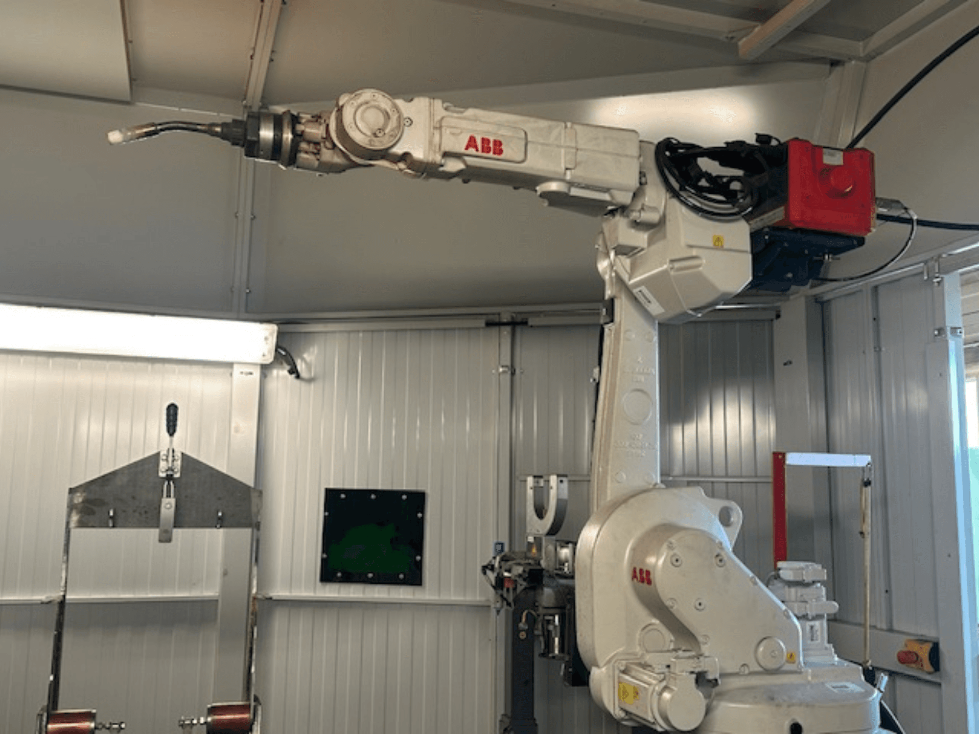ABB Schweißroboter Flex Arc - skats no sāniem uz robotizēto roku ar metināšanas instrumentu, kurā redzamas tādas detaļas kā vadības panelis un kabeļi.