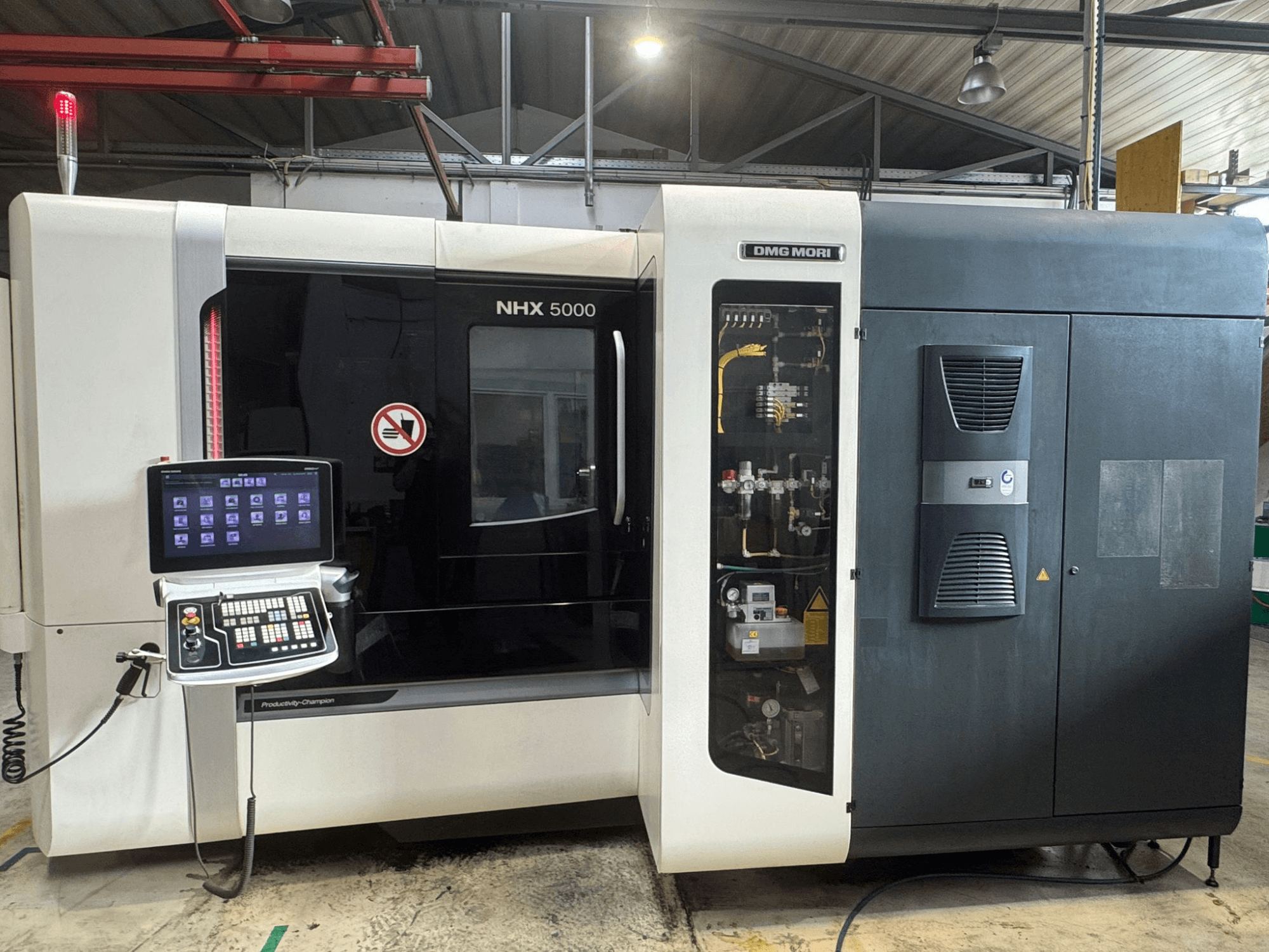 DMG MORI NHX 5000 horizontālā apstrādes centra priekšējais skats, kurā redzams vadības panelis un mašīnas detaļas.