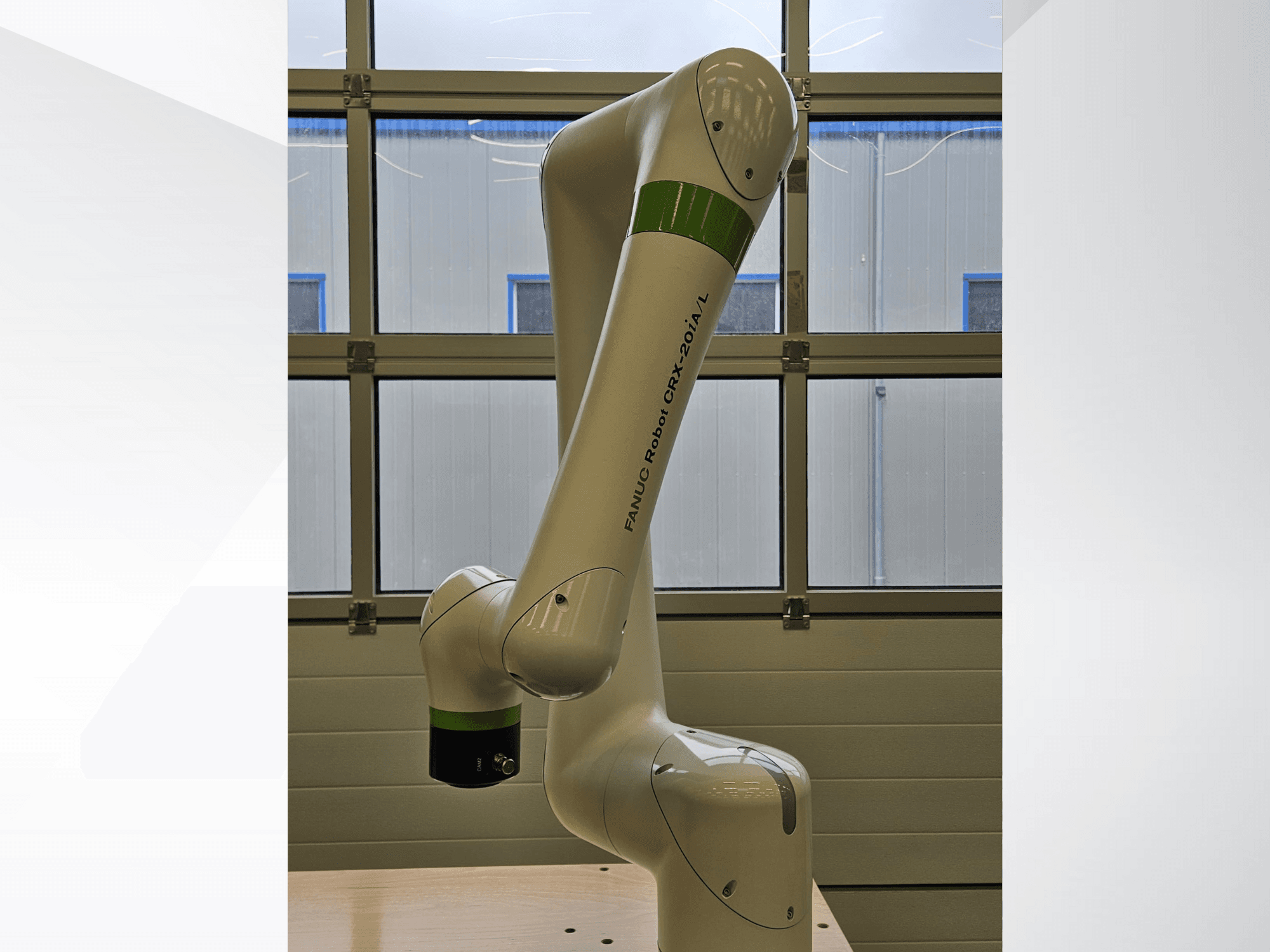 FRANKA ROBOT CRX-20A/L, skats no sāniem, ar locītavu roku un zaļās un melnās krāsas satveršanas galējo efektoru.