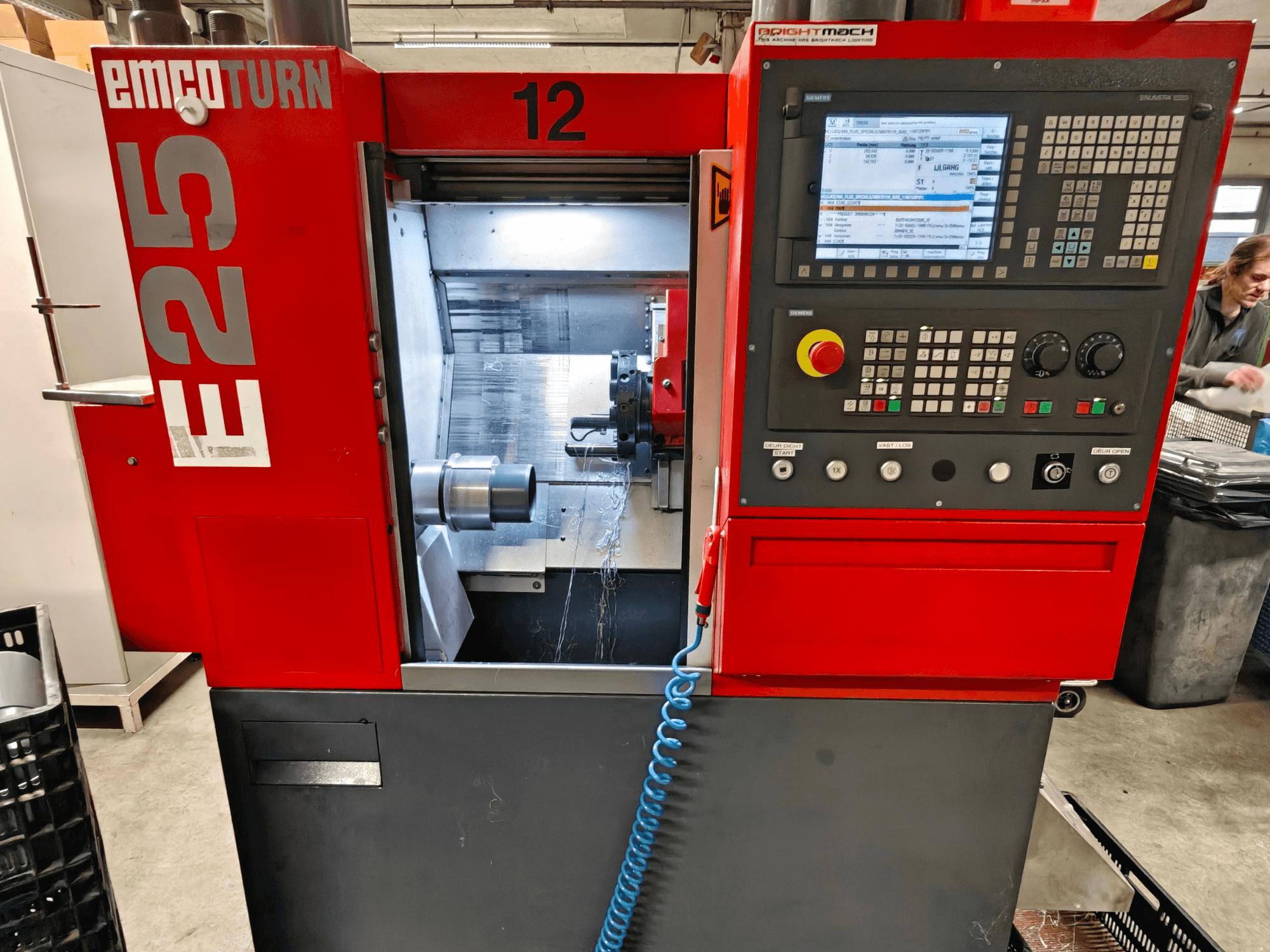 EMCO TURN E25 mašīnas priekšējais skats, kurā redzams vadības panelis, instrumentu turētājs un iekšējā zona ar redzamu griezējinstrumentu.