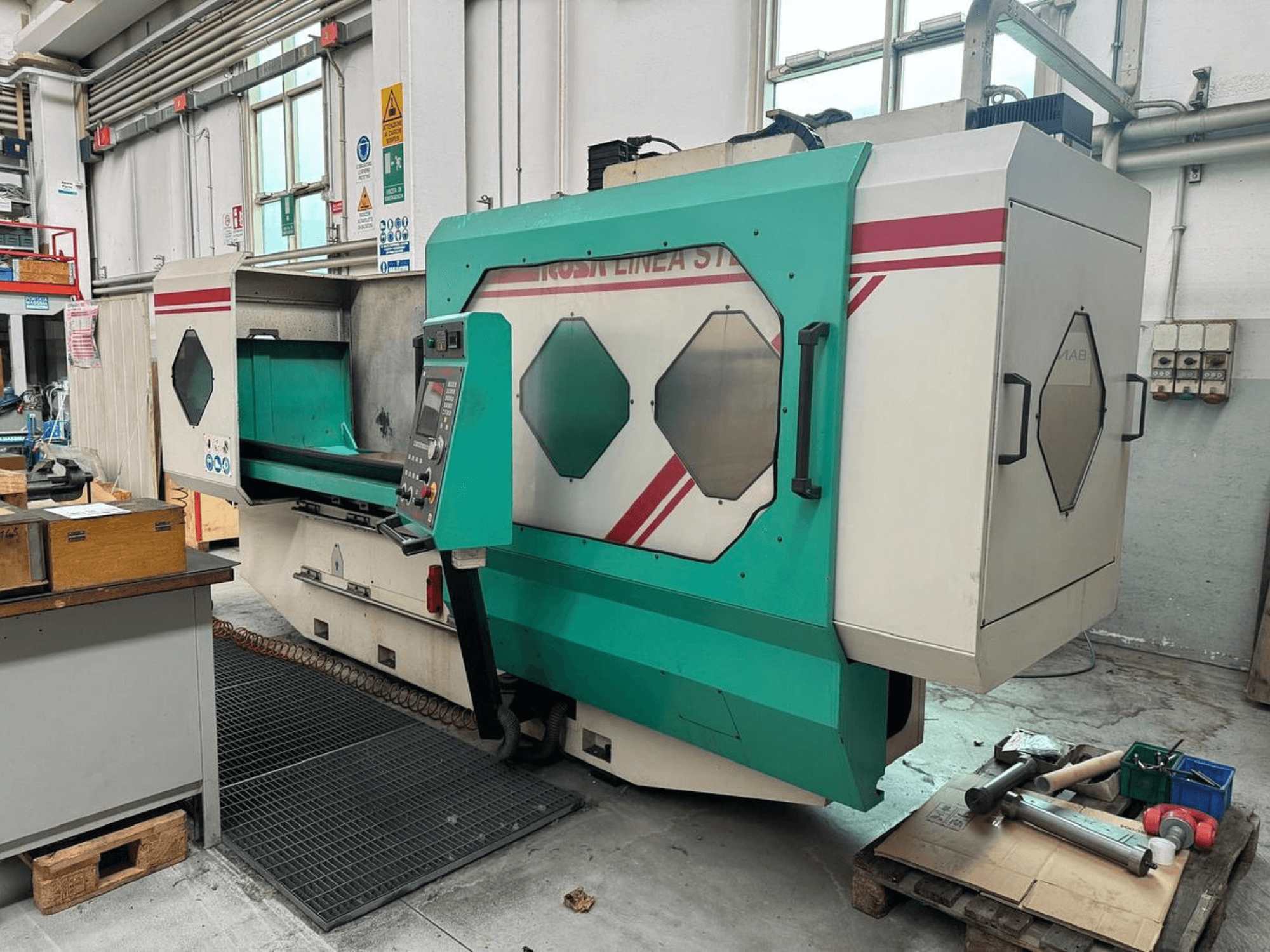 Zaļbaltā precīzijas mašīna, skats no priekšpuses, ar vadības paneli, darba zonu un instrumentiem uz paliktņa. Zīmols: BAMB.