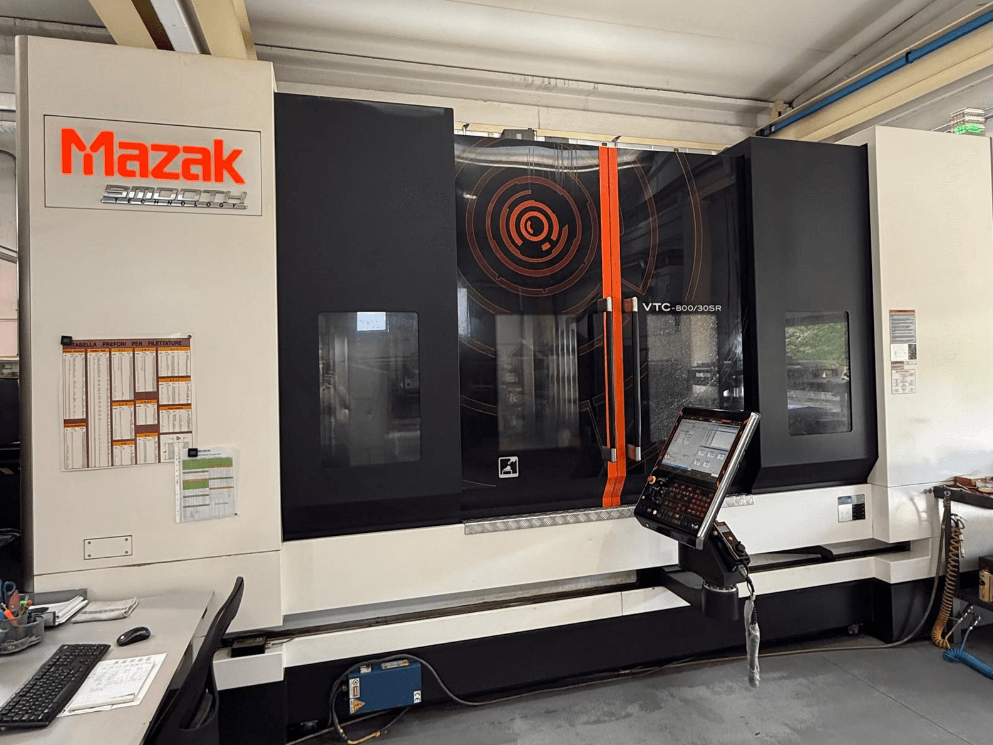 Vertikālais apstrādes centrs „Mazak VTC-800/30SR“ — skats no priekšpuses, kurā redzams vadības panelis, displejs un darba zona.
