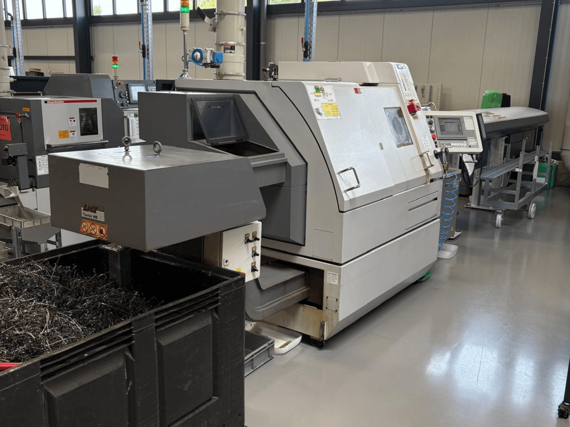 LTA Turbo H8 rūpnieciskā mašīna, skats no sāniem, ar lielu metāla skaidu tvertni un vadības paneli rūpnīcā.