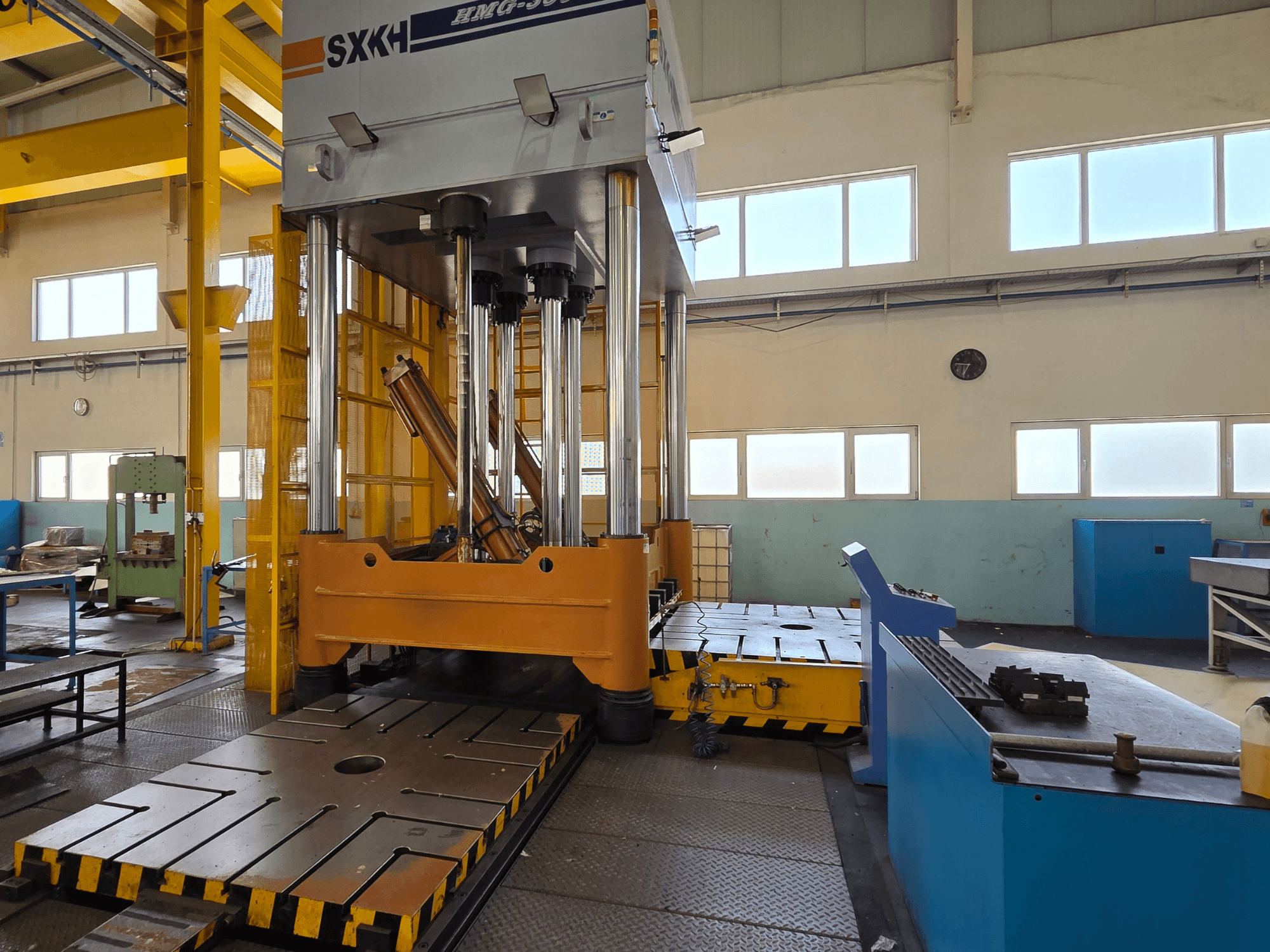 Hidrauliskā prese SXKH HMG-300JM ar lieliem presēšanas cilindriem un izturīgu pamatni rūpnīcas apstākļos.